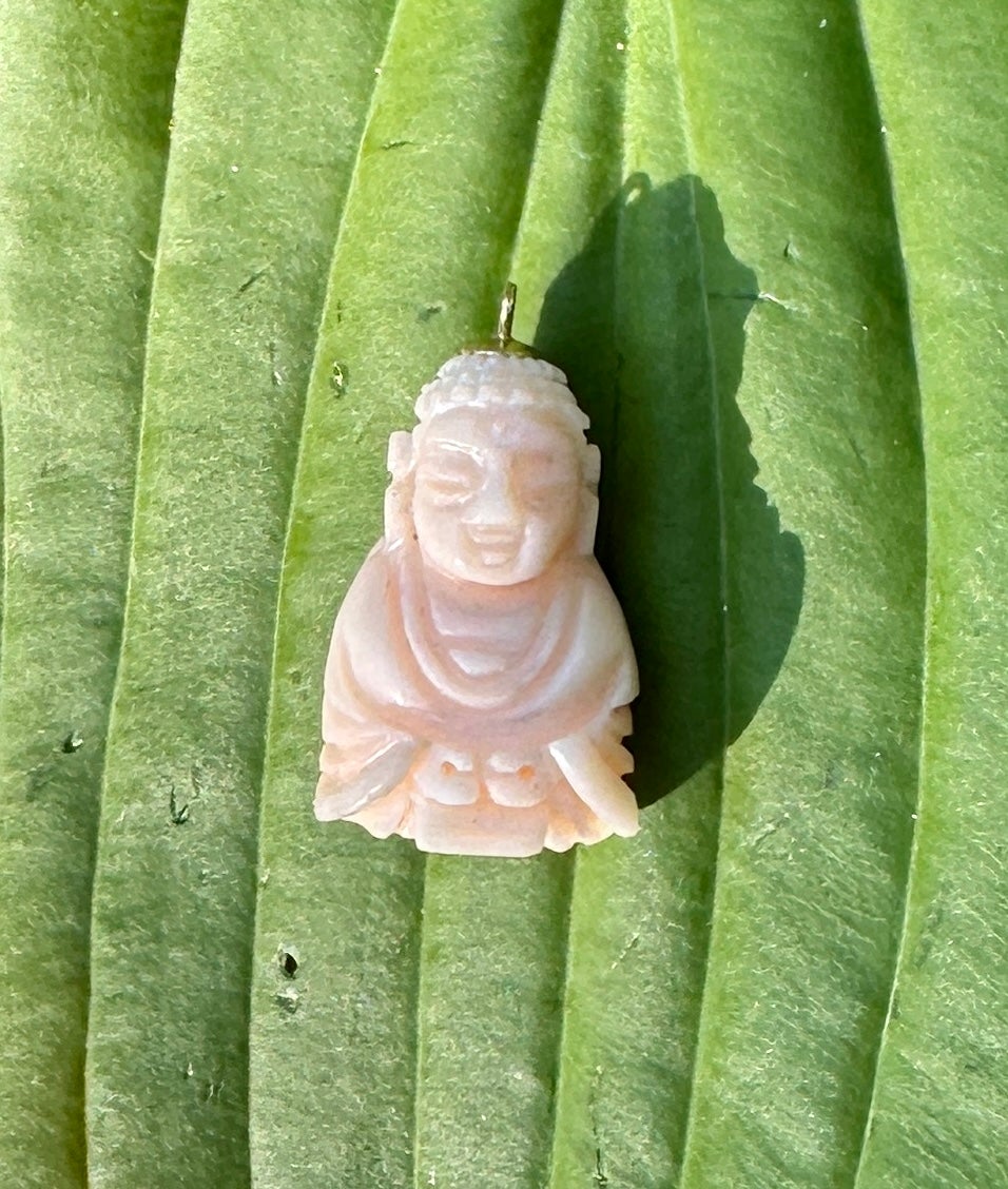 This is a wonderful antique Art Deco Angel Skin Coral Buddha Pendant or Charm in 14 Karat Yellow Gold.  The Buddha is exquisitely carved in natural Angel Skin Coral.  The Buddha miniature is a beautiful creation with wonderful details in the face,