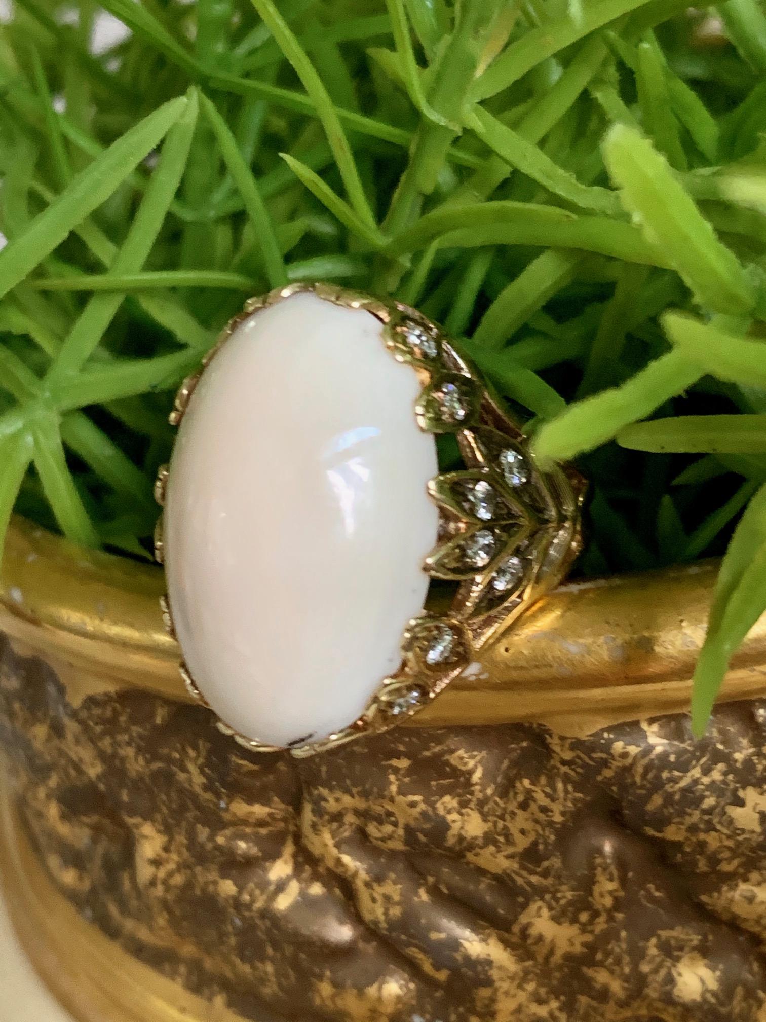 Oh my, this ring is amazing.  It features an angel Skin Coral cabochon measuring 23 x 16mm and 16 2mm European cut side Diamonds totaling approximately .60ctw.
Average grades: VS-G

Size: 6 1/4
Weight: 13.39