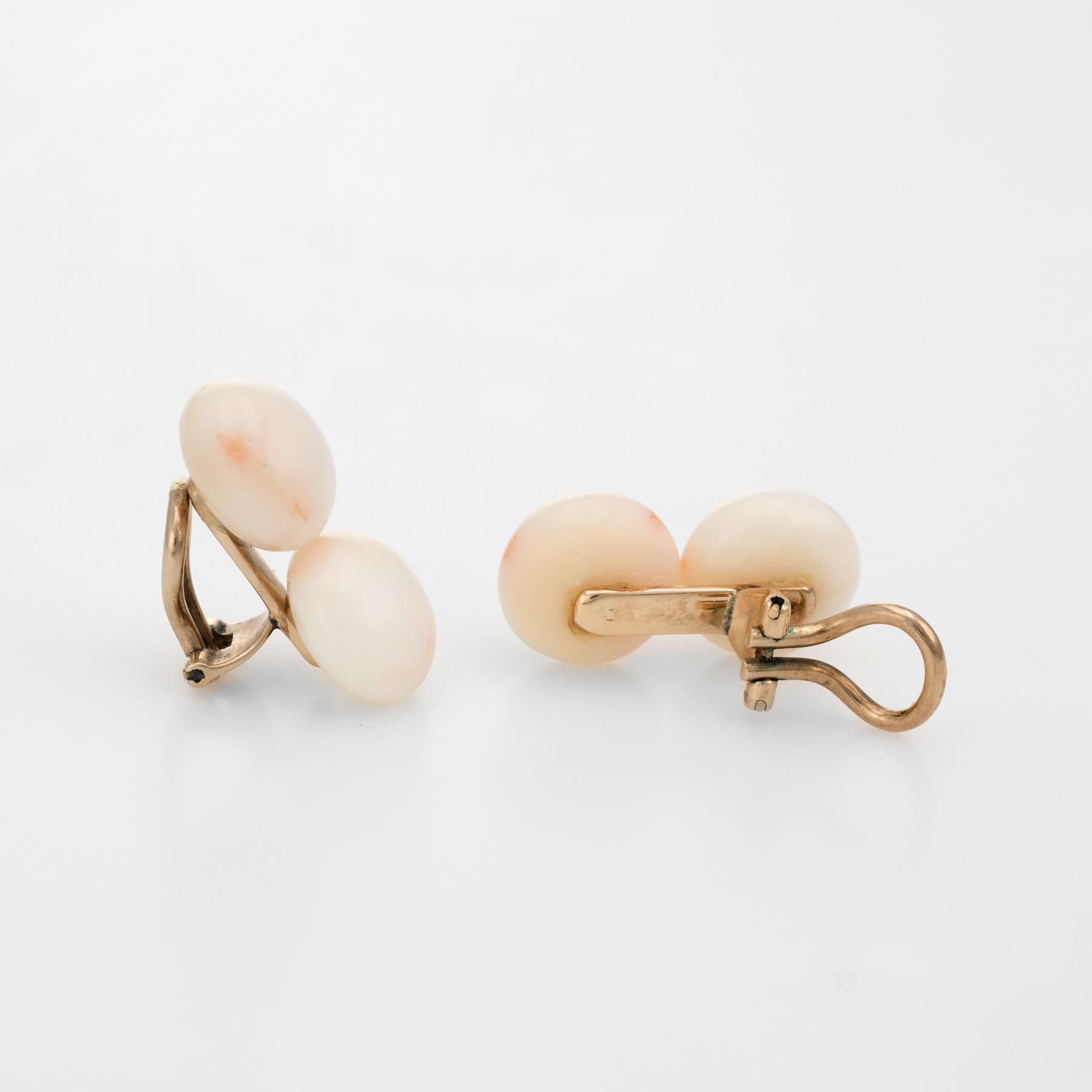 Elegant pair of vintage angel skin coral earrings (circa 1950s to 1960s), crafted in 14k yellow gold. 

Cabochon cut angel skin coral measures 11.5mm (each). The coral is in excellent condition and free of cracks or chips. 

The earrings feature