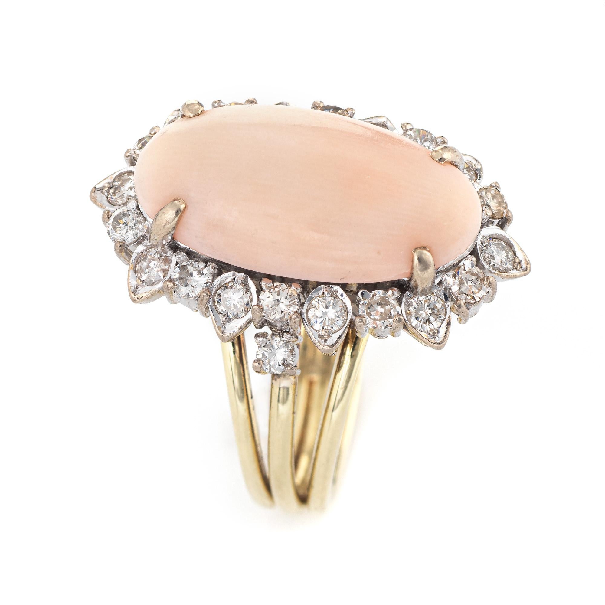 Stylish vintage coral & diamond cocktail ring (circa 1950s to 1960s) crafted in 14 karat white gold. 

Angel skin coral is cabochon cut measuring 17mm x 9mm (estimated at 4.50 carats), accented with 23 estimated 0.02 carat diamonds. The total