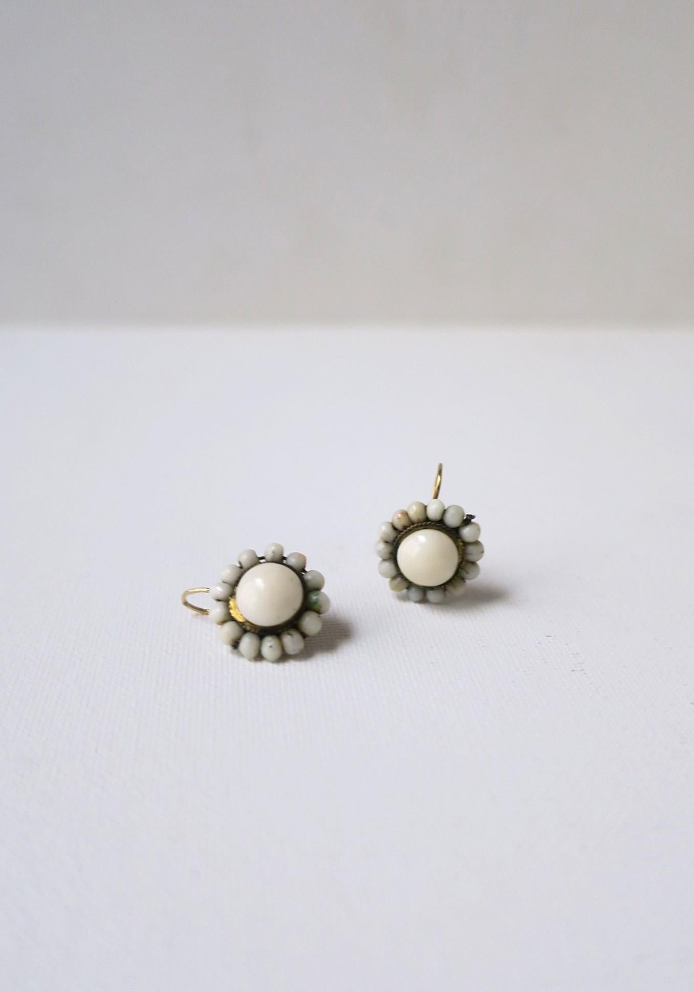 Un paio di orecchini a goccia in corallo a forma di pelle d'angelo con retro a filo in oro giallo 14 carati, circa inizio XX secolo, forse provenienti dall'Italia. Gli orecchini hanno un centro rotondo di corallo angelo circondato da perline rotonde