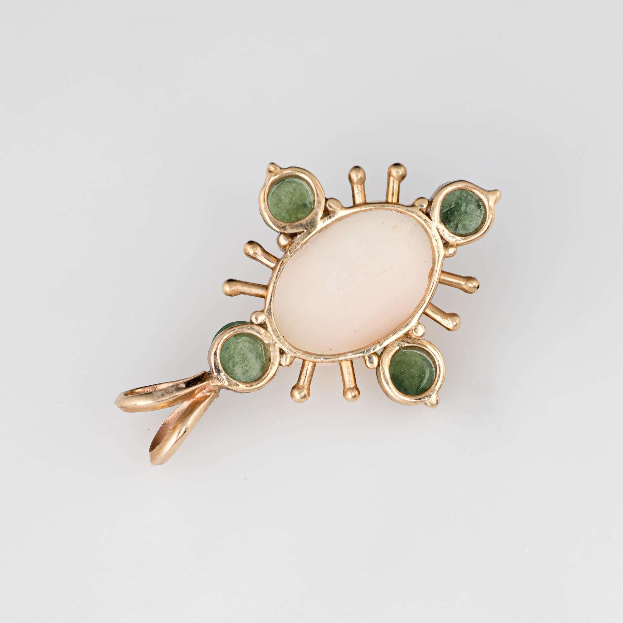 Finely detailed vintage angel skin coral & jade pendant (circa 1950s to 1960s) crafted in 14k yellow gold.  

Angel skin coral measures 13mm x 9mm (estimated at 5 carats), accented with four piece of jade measuring 4mm each. The coral and jade is in