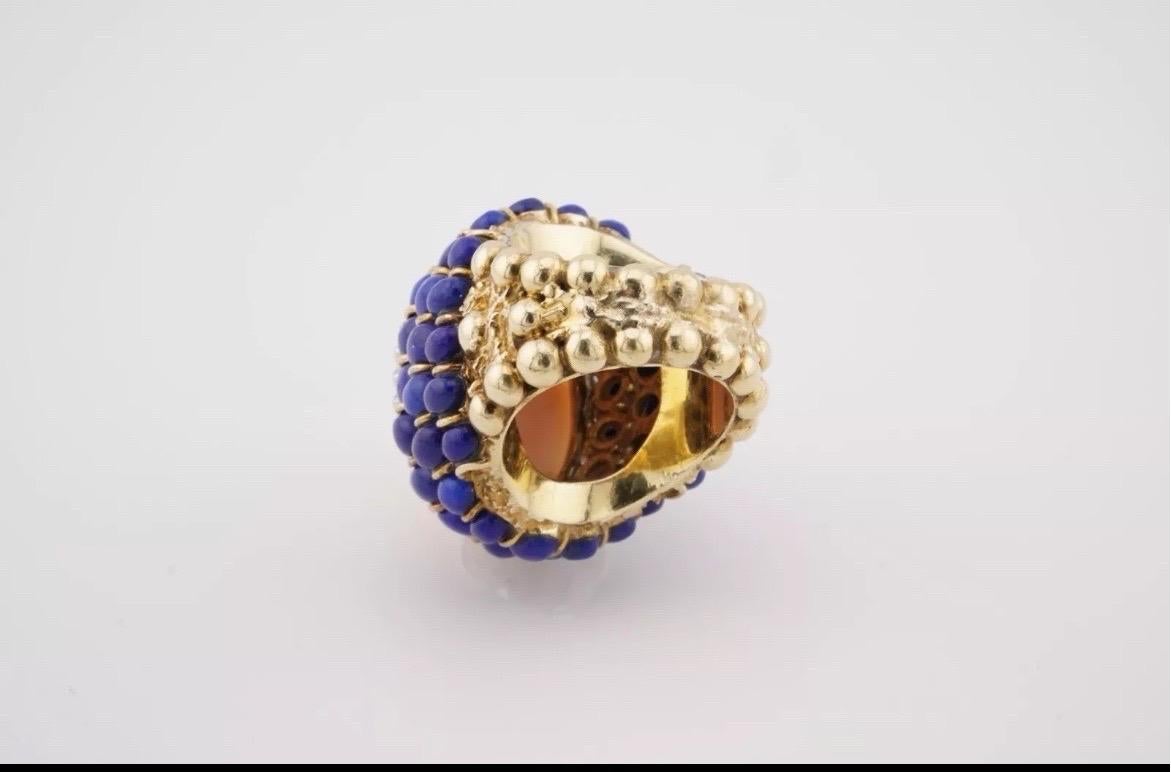 Bold, elegant, and beautifully unique, this vintage estate cocktail ring showcases a captivating blend of color and sparkle. At its heart is a soft, blush-toned oval angel skin coral cabochon, celebrated for its delicate, natural beauty. Surrounding