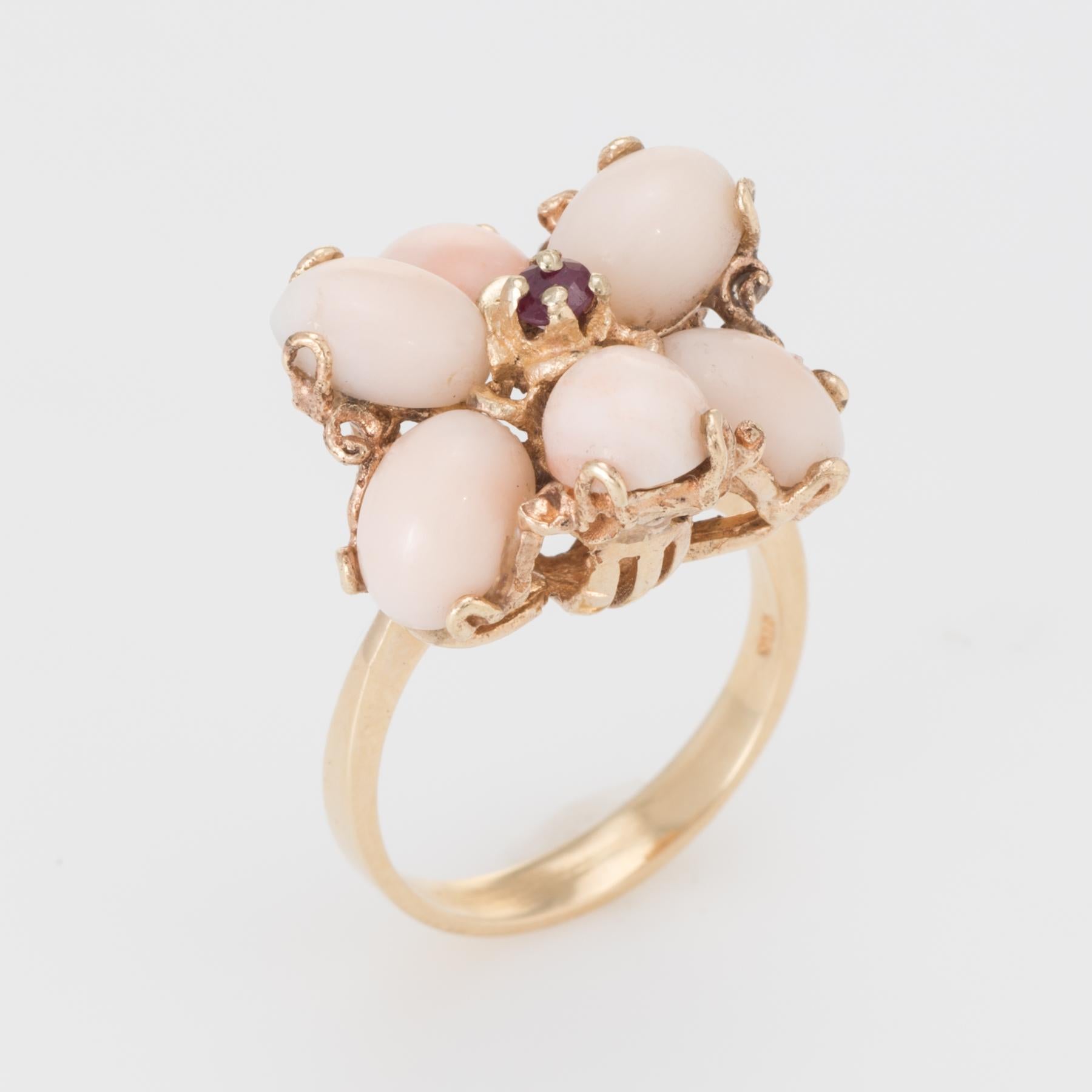 Distinct vintage cocktail ring (circa 1960s), crafted in 14 karat yellow gold. 

Angel skin coral each measures 8mm x 6mm (total estimated weight of 7.50 carats), accented with an estimated 0.05 carat ruby. The coral is in excellent condition and