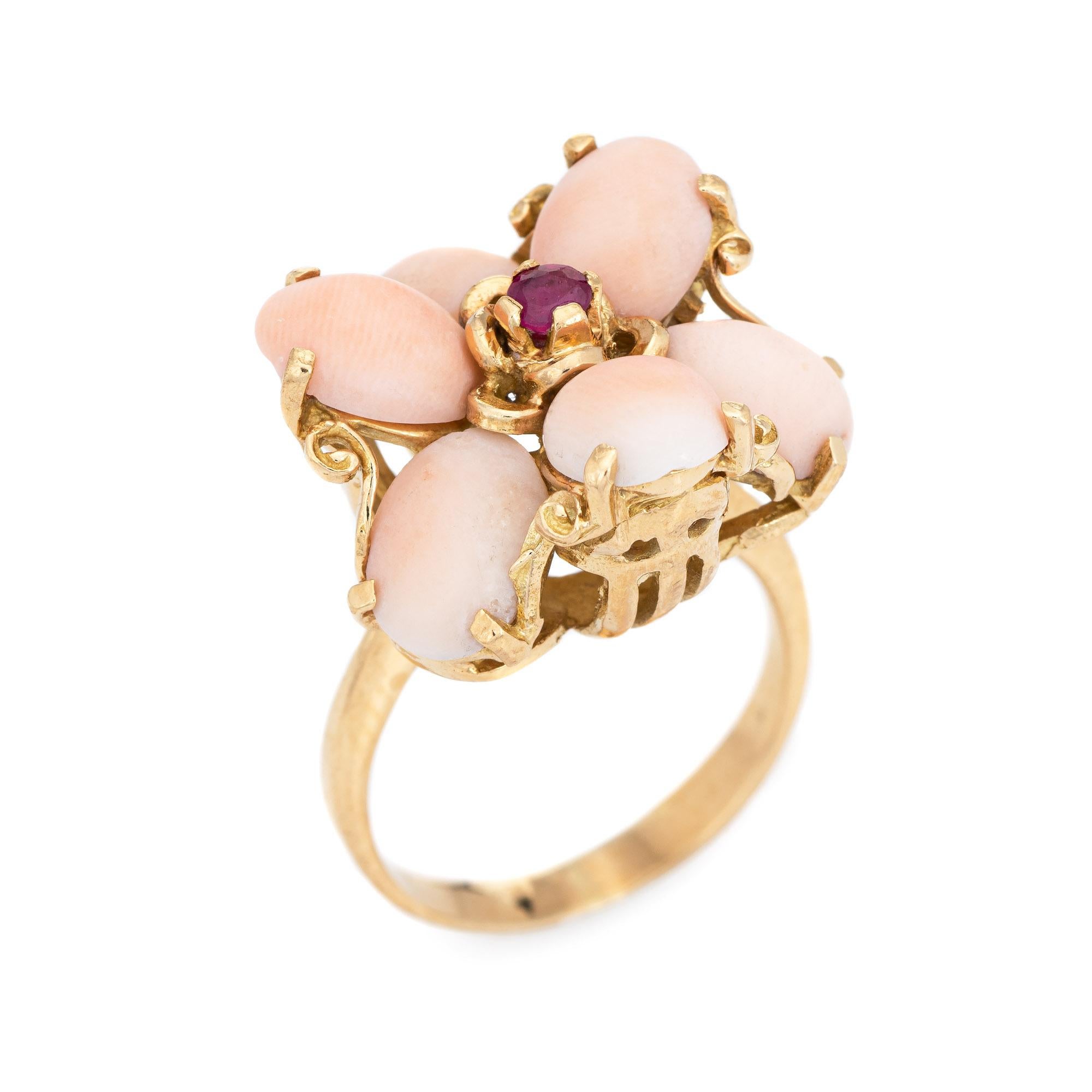 Stylish angel skin coral & ruby flower cocktail ring crafted in 18 karat yellow gold (circa 1970s). 

Cabochon cut coral measures 8mm x 6mm (estimated at 1.25 carats each - 7.50 carats total estimated weight). One estimated 0.05 carat ruby is set to