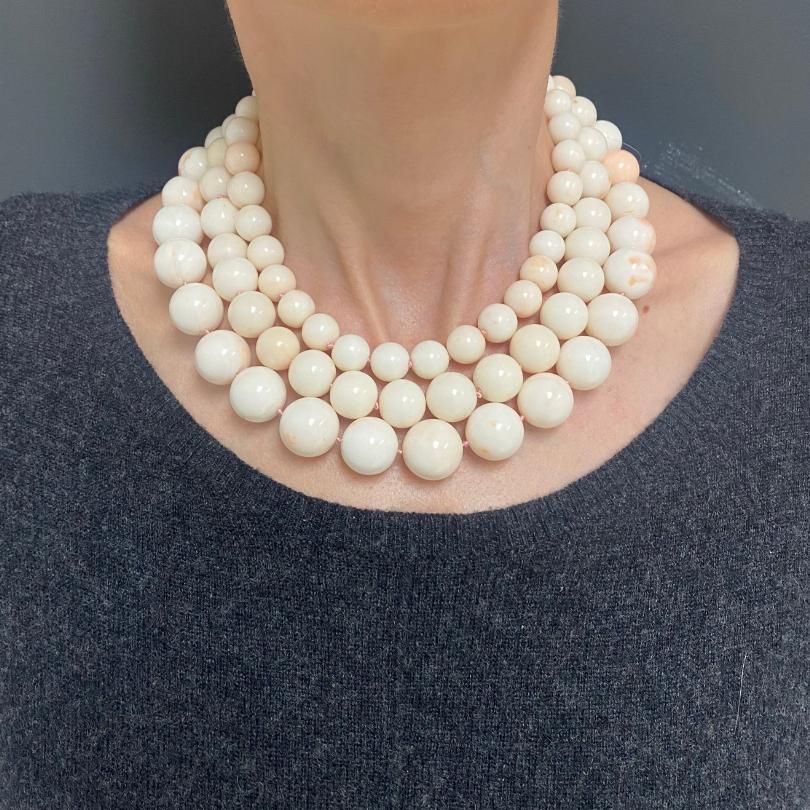 A luxurious triple-strand necklace featuring natural Angel Skin Coral beads in graduated sizes, secured with a 14K yellow gold clasp.
Bead Sizes: Smallest bead diameter is 1/2