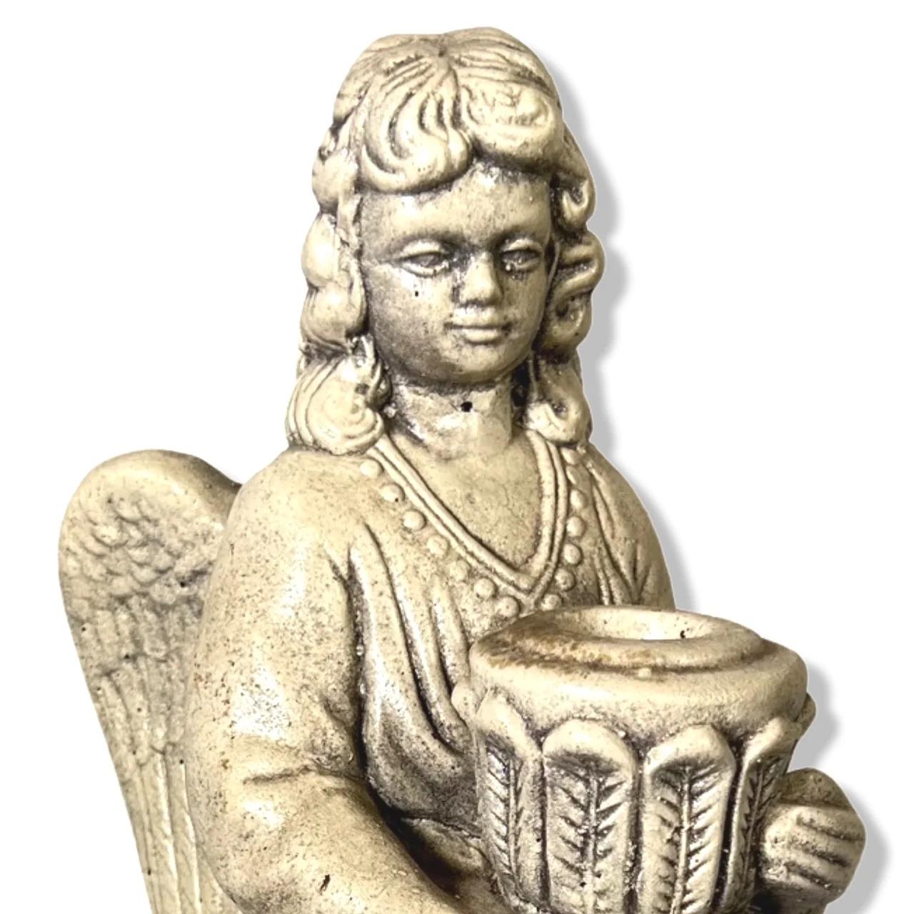 This petit Angel stone and cement cast statue can be used in multiple ways. Firstly, as a quaint garden statue on its own, or in the interior of your home as a candle holder. The angel herself, is holding a candle holder which is the perfect size