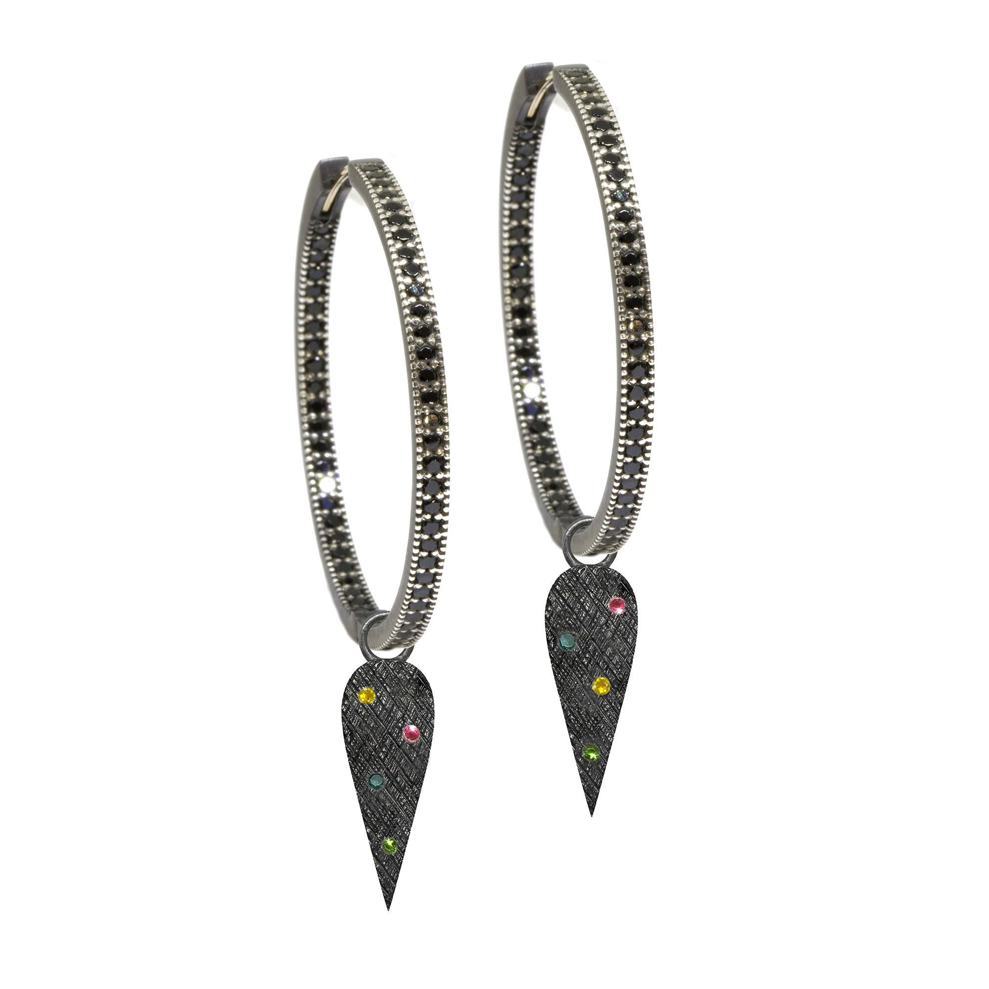 The perfect everyday style, especially when you want a subtle pop of color, the Angel Wings 20mm Oxidized Charms scatter tourmalines on a blackened silver background detailed with a feather-like crosshatch pattern.

Nina Nguyen Design's