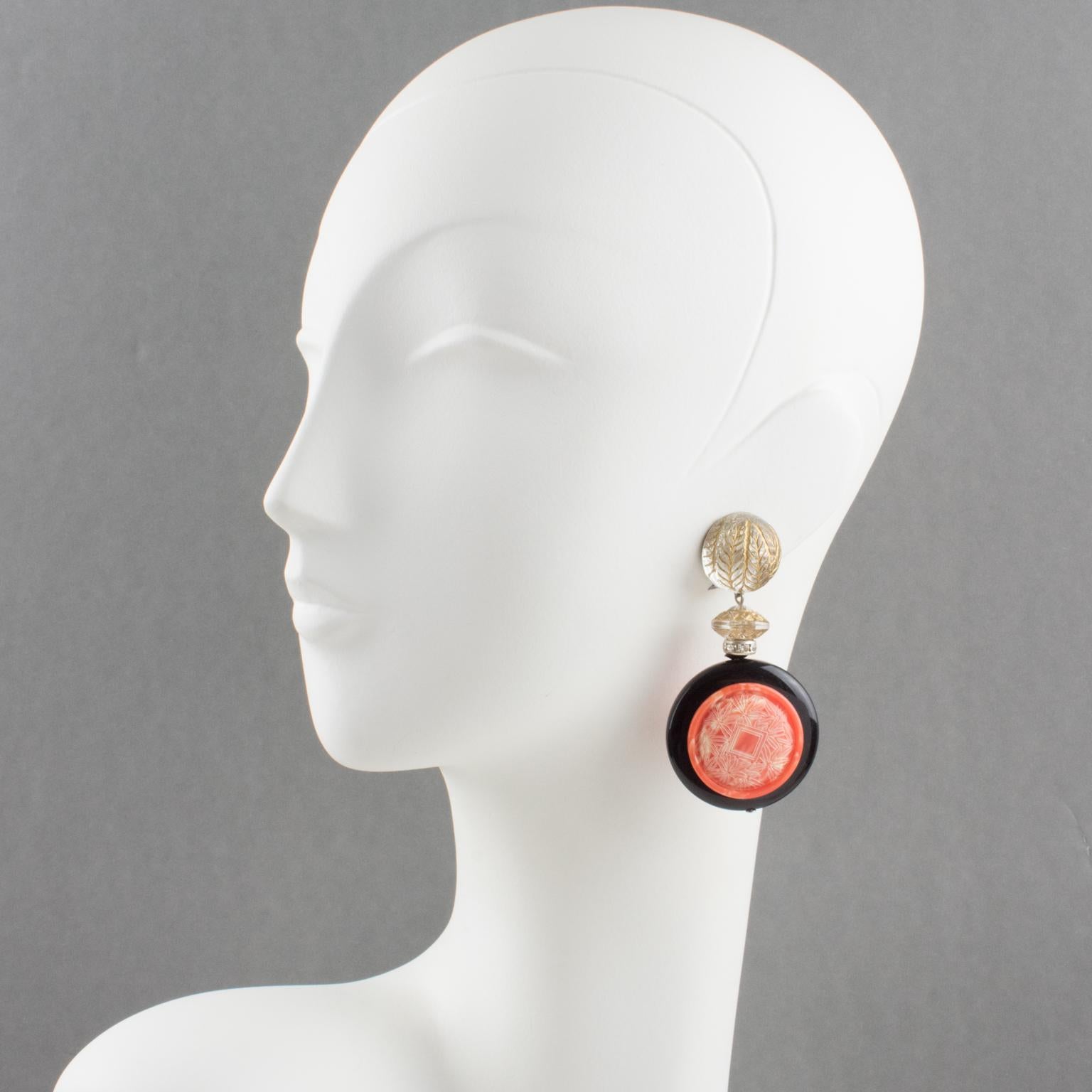 Sophisticated Angela Caputi, made in Italy resin clip-on earrings. Oversized dangling shape with dimensional black color disk topped with faux coral medallion with Asian-inspired carving. The design is contrasted with crystal clear carved beads and