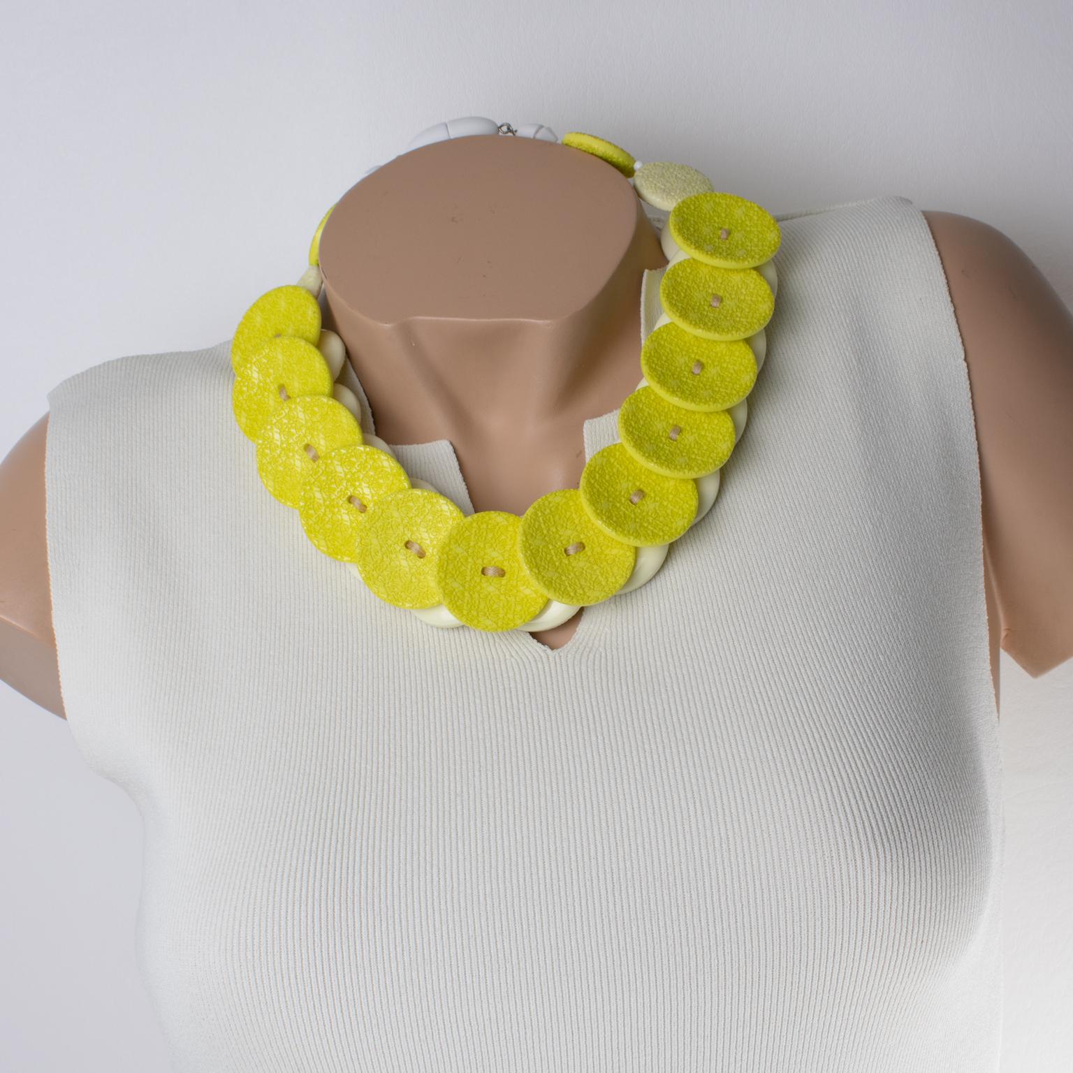 Realizzata a mano in Italia, questa splendida collana girocollo in resina di Angela Caputi presenta una tonalità giallo agrumi con contrasto banana e bianco. Il girocollo vanta dischi piatti e grossi che imitano bottoni giganti con un motivo