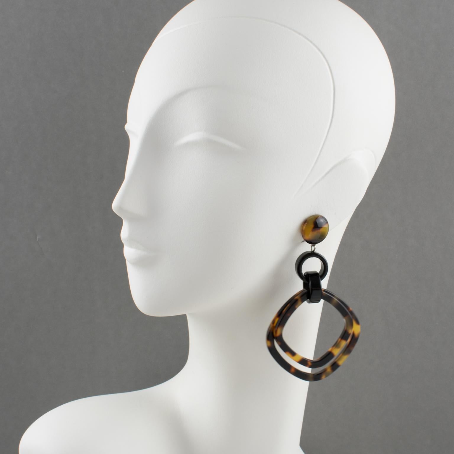 Elegant, made in Italy, resin clip-on earrings designed by Angela Caputi. A dangling shape with black resin geometric links contrasted with large geometric hoops in a tortoise textured pattern. Her matching of colors is always extremely classy,