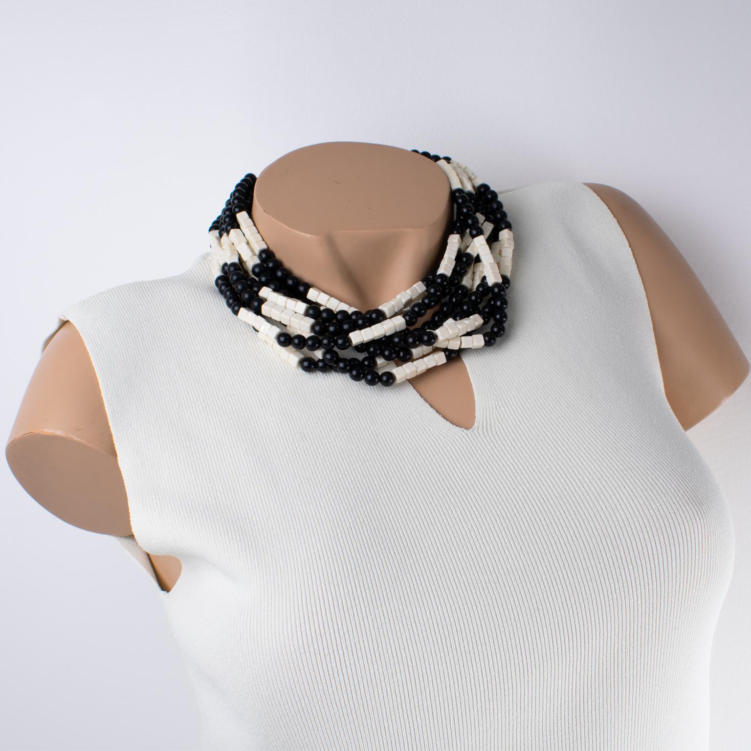 Diese wunderschöne Angela Caputi Halskette aus Harz, die in Italien hergestellt wird, zeichnet sich durch ein mehrsträngiges Design in schönen schwarzen und creme-weißen Farben aus. Die Designerin spielt mit den Formen der Perlen und verwendet