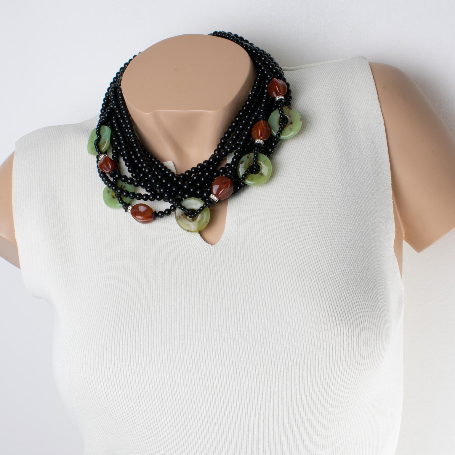 Angela Caputi ha realizzato questa splendida collana di perline in resina in Italia. Il girocollo presenta un design oversize a più fili con perline dominanti di colore nero in contrasto con elementi a ciambella verde finto-jade e perline di