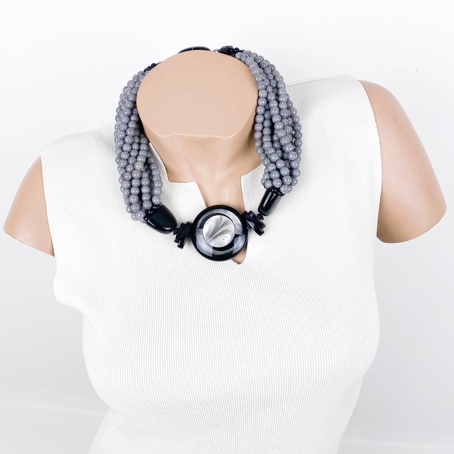 This stunning Angela Caputi, made-in-Italy, resin choker necklace features a multi-strand design with a dominant mouse gray color contrasted with a black tone. The necklace is adorned with a central round medallion in black and pearlized gray with a