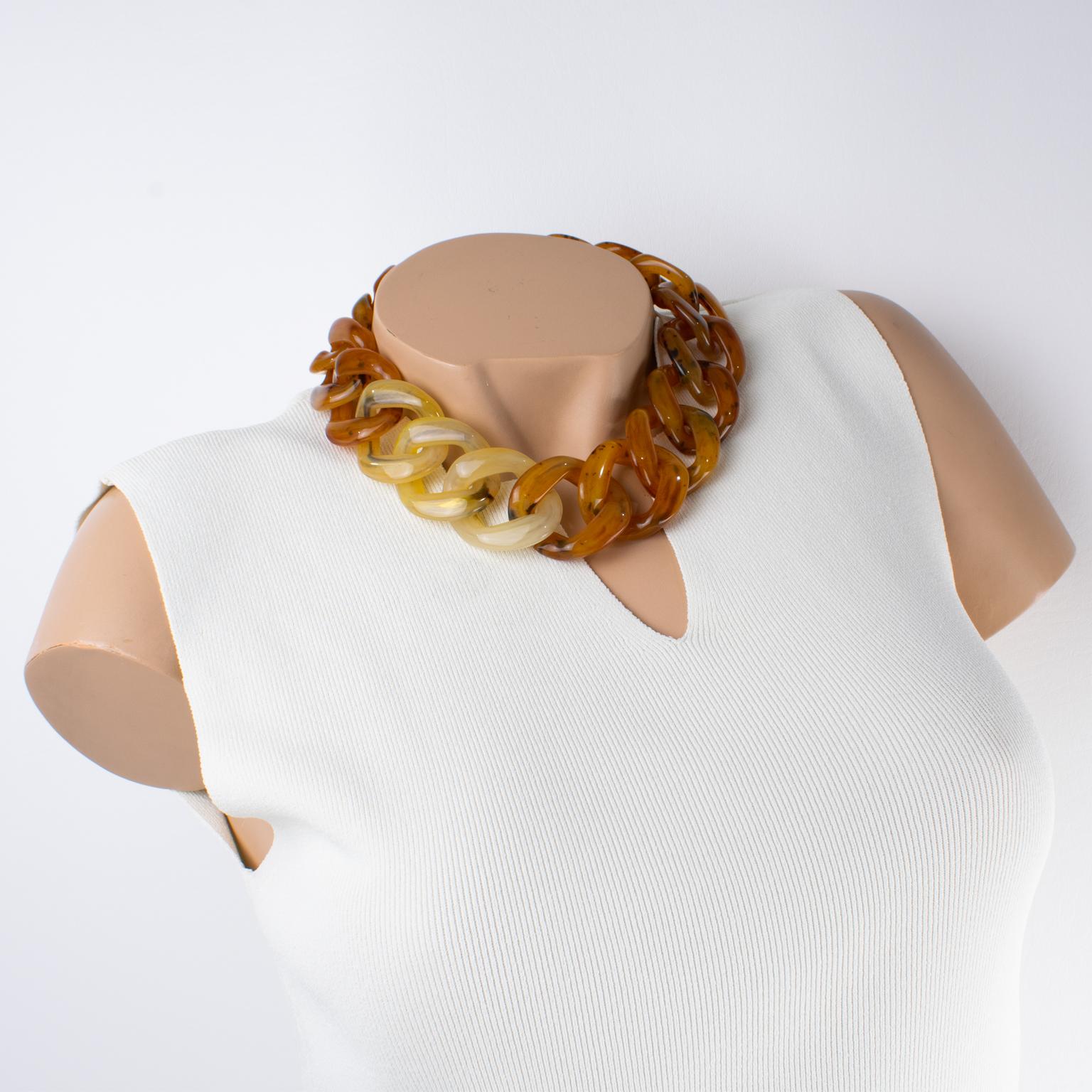 Este impresionante collar gargantilla Angela Caputi, fabricado en Italia, presenta un diseño de cadena plana de resina extragrande en tono carey texturizado con remolinos de color amarillo claro y limón en contraste. Su combinación de colores es