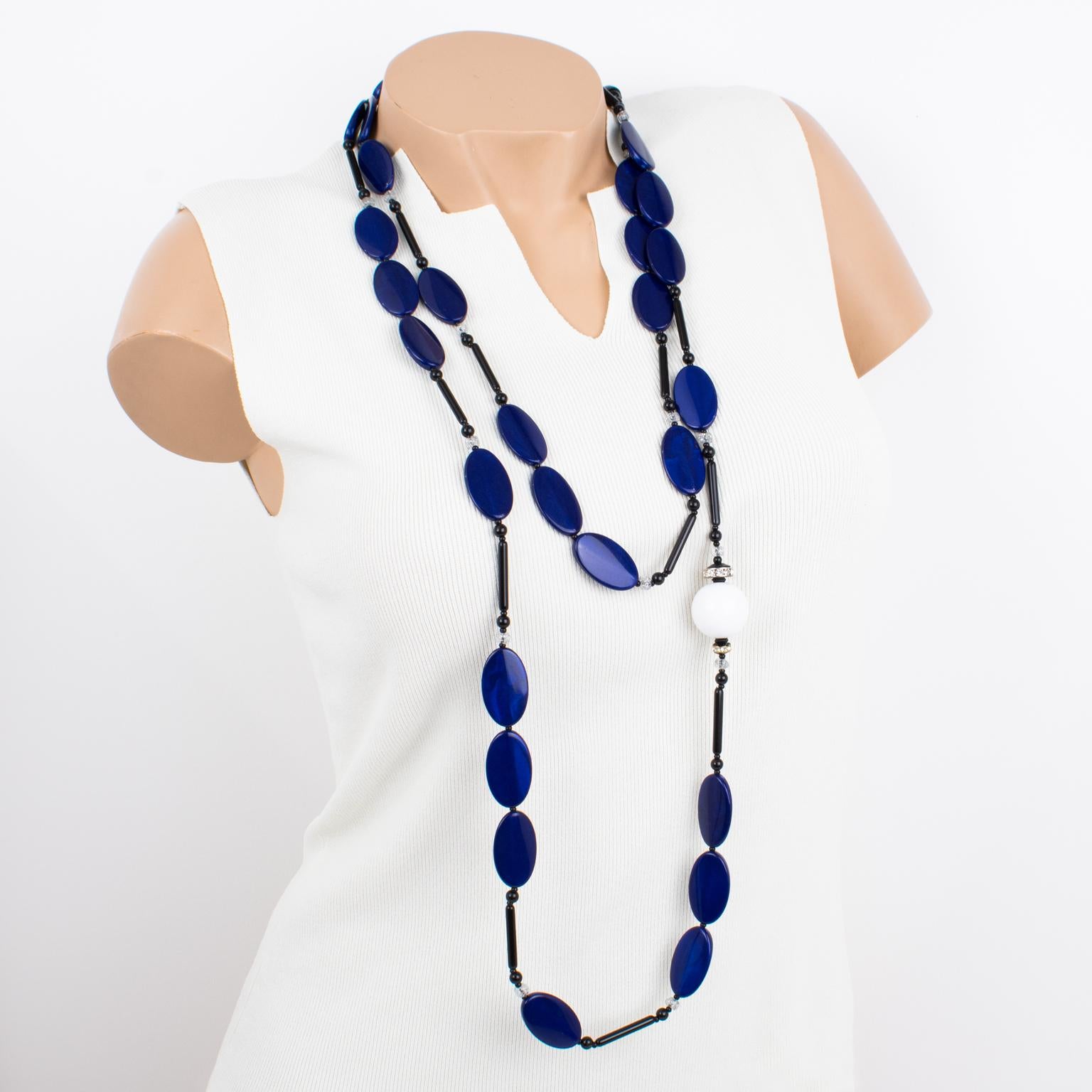 This stunning Angela Caputi necklace features a giant extra-long beaded design built with faux-lapis blue flat oval elements, complimented with a large white resin bead and ornate with black stick beads. Her color matching is always bold and