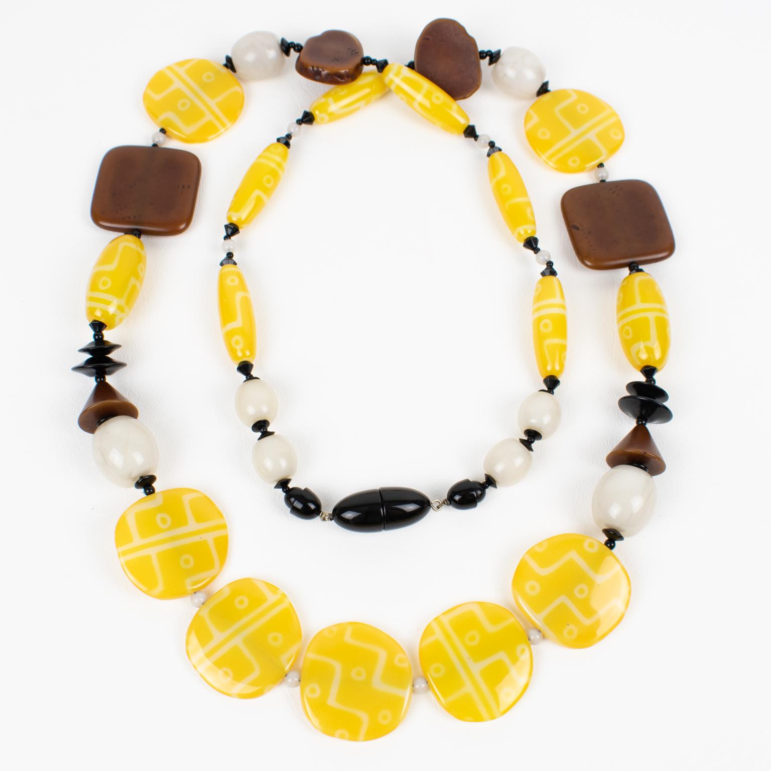 Ce superbe collier d'Angela Caputi présente un design extra-long en perles, composé de galets jaunes texturés, complété par des perles en résine de faux bois et orné d'entretoises blanches et noires. Ses couleurs sont toujours audacieuses et