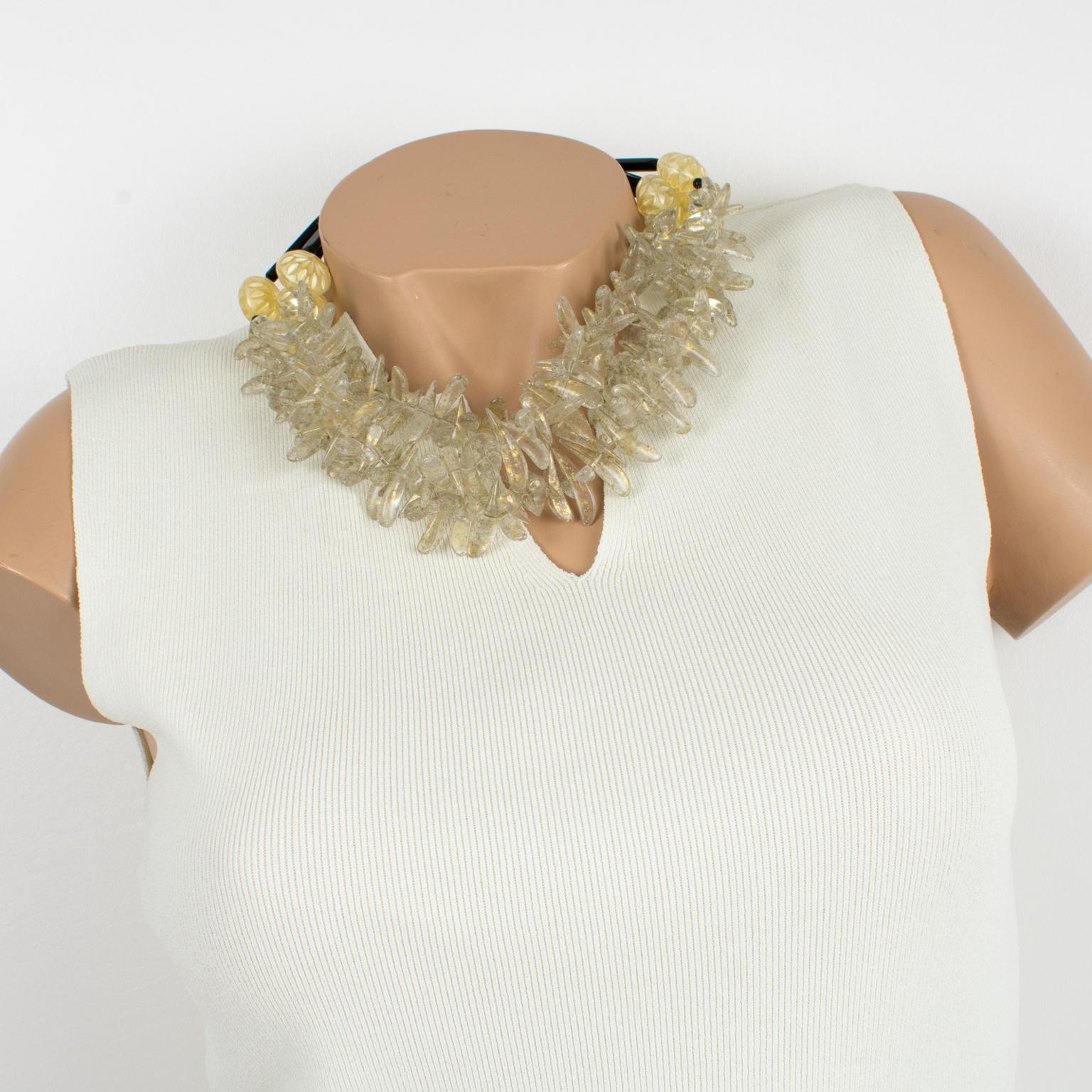 This elegant Angela Caputi, made-in-Italy resin choker necklace features chunky spike beads with gold flakes inclusions and works on a transparent-gold color with black contrast. The multi-strand shape is embellished with black stick beads and