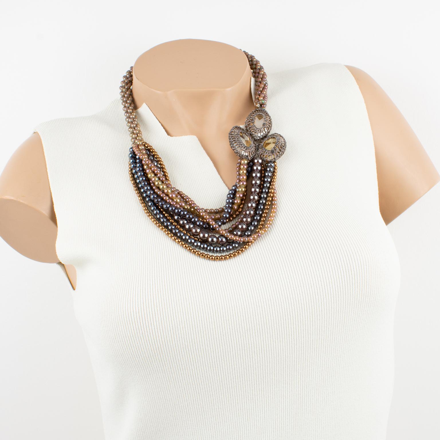 Angela Caputi designed this ultra-chic choker necklace in Italy. The multi-strand design boasts pearl-like beads and a large side medallion. This unusual pattern is built with pearl-like glass beads in golden brown, gunmetal, and antique rose