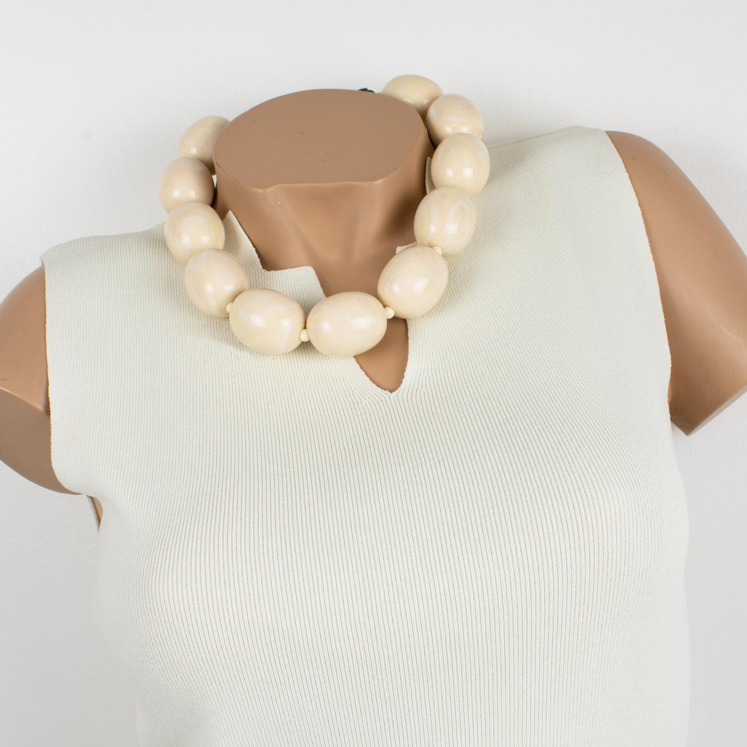Questa elegante collana girocollo in resina di Angela Caputi, realizzata in Italia, presenta una forma minimalista con perline ovoidali oversize di colore avorio con una sfumatura rosa. I suoi abbinamenti di colore sono sempre di gran classe,