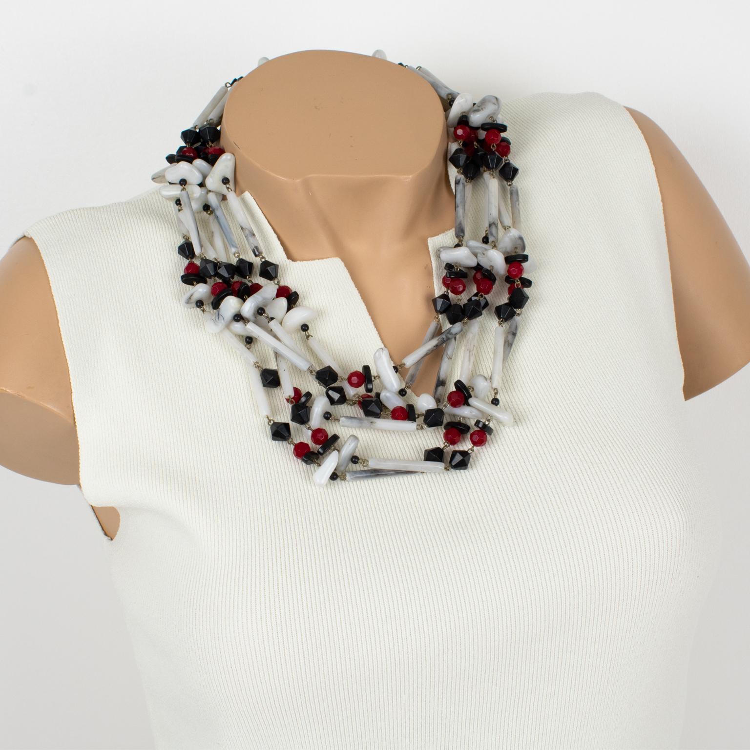 This lovely Angela Caputi, made in Italy resin choker beaded necklace features an oversized multi-strand design with assorted pebble and long stick beads in red, black, and white colors. The white-colored resin beads have a faux Carrara marble