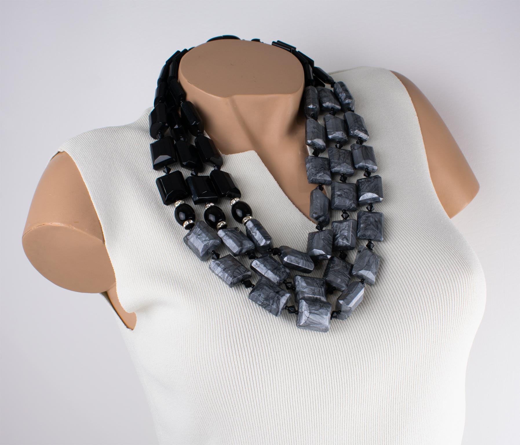 Un'eccezionale collana a girocollo in resina con perline, disegnata da Angela Caputi e realizzata in Italia. Il pezzo a più fili presenta un contrasto grigio perlato e nero; ogni sassolino è intagliato, dimensionale e geometrico. L'aggiunta di