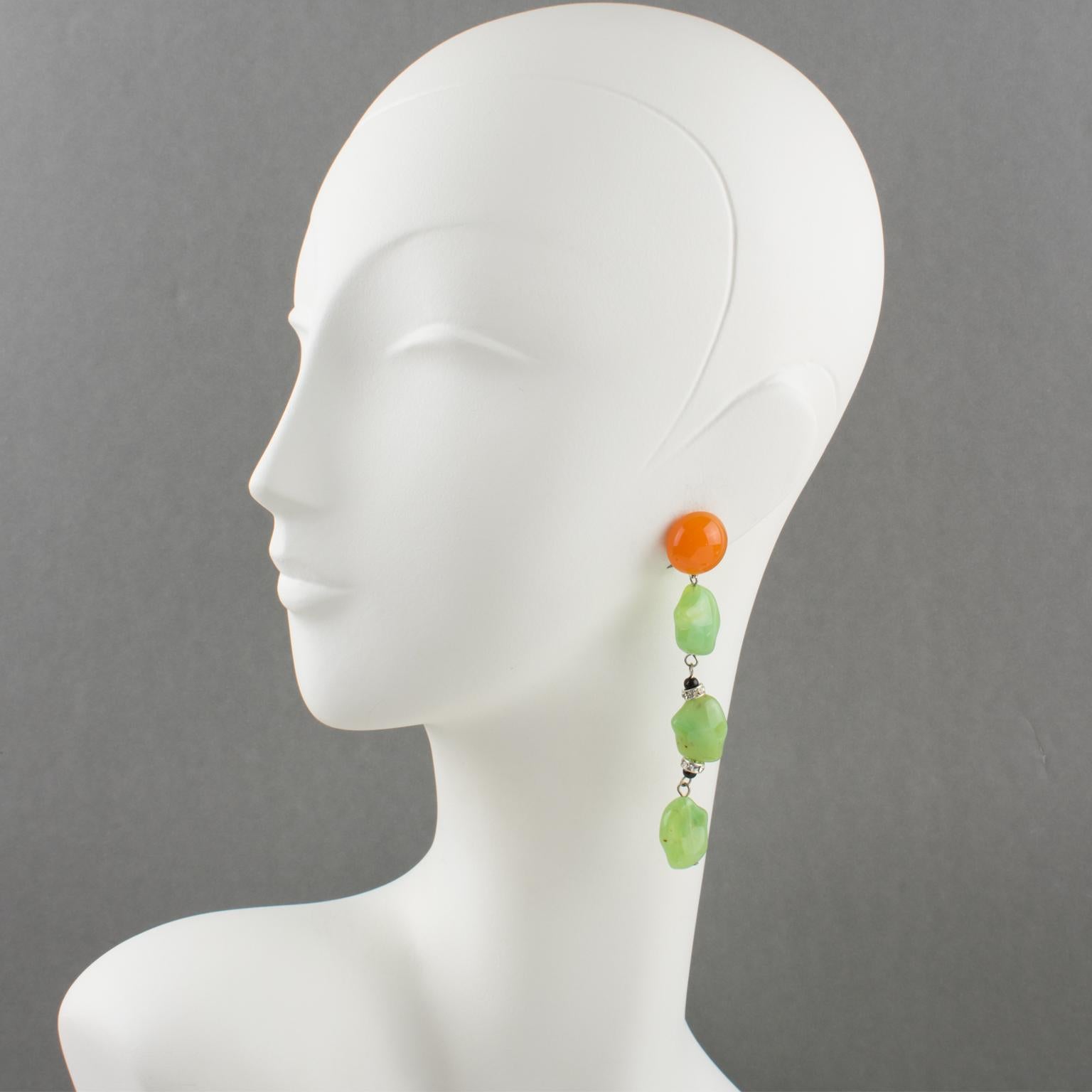 These elegant Angela Caputi resin clip-on earrings were made in Italy. The dangling pebble shape is built with a tangerine orange color contrasted with faux-jade green color beads and complimented with crystal rhinestone spacer rings.
As you know,