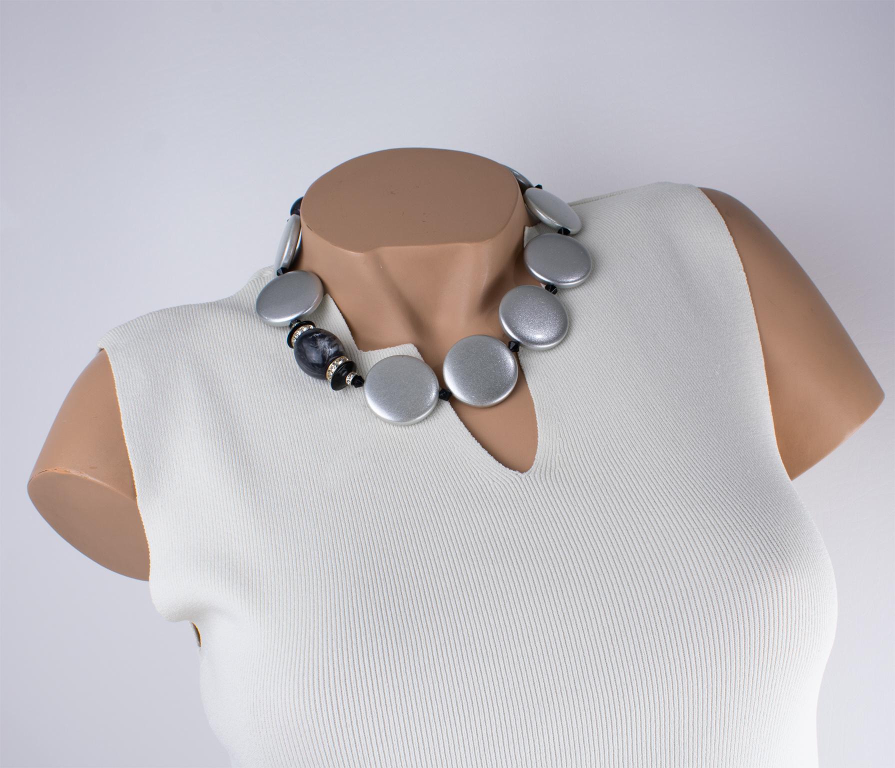 Realizzata a mano in Italia, questa bellissima collana in resina di Angela Caputi presenta una tonalità argento perlato con contrasto nero. Questo raro girocollo è caratterizzato da ciottoli grossi e arrotondati con una trama argentata, abbinati a