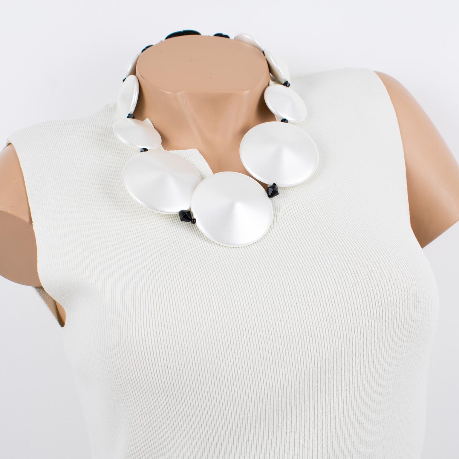 Handcrafted in Italy, this beautiful Angela Caputi resin necklace features a pearlized white tone with black contrast. The rare choker features chunky, domed pebbles in a pearl-imitation textured pattern, paired with black bead spacers. Her color