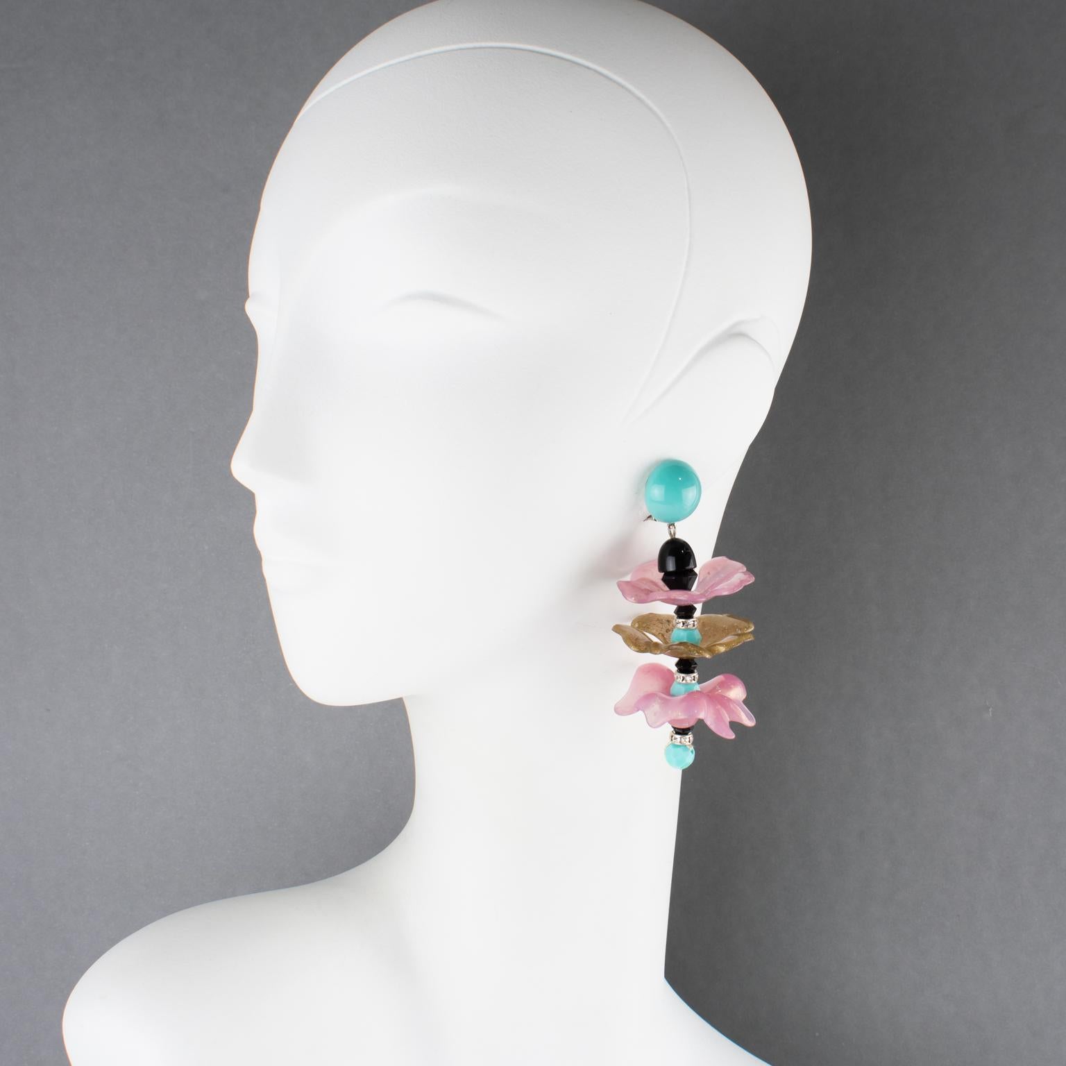 Questi splendidi orecchini a clip in resina made-in-Italy di Angela Caputi presentano un importante design pendente con elementi floreali a forma di onda. I pezzi vantano colori rosa antico, oro, turchese e nero. Questi orecchini appartengono alla
