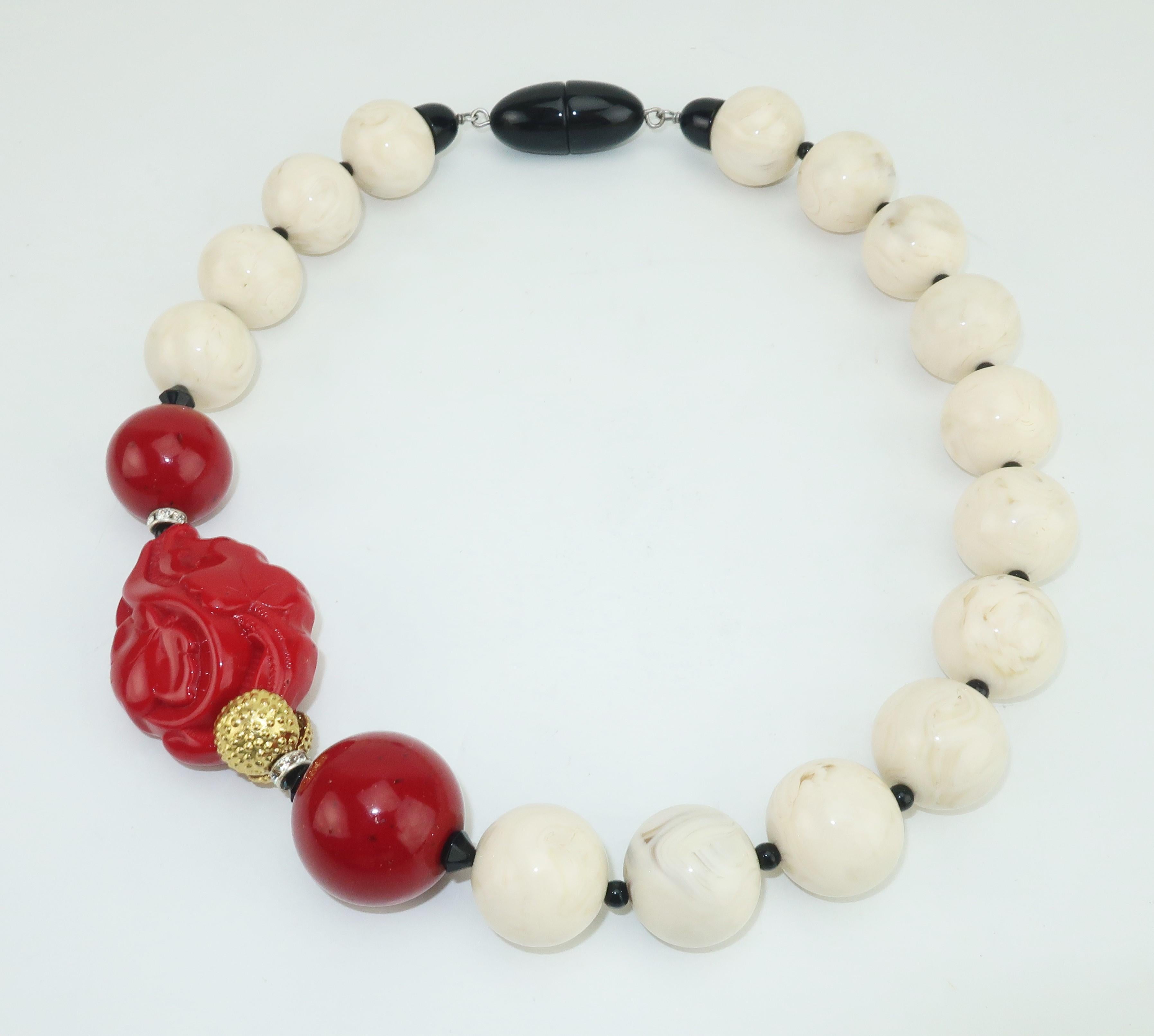 A beautiful statement making necklace from Italian designer, Angela Caputi.  The Asian inspired design is reminiscent of Art Deco creations with a combination of resin beads in shades of ivory, onyx and coral or cinnabar.  A subtle touch of crystal