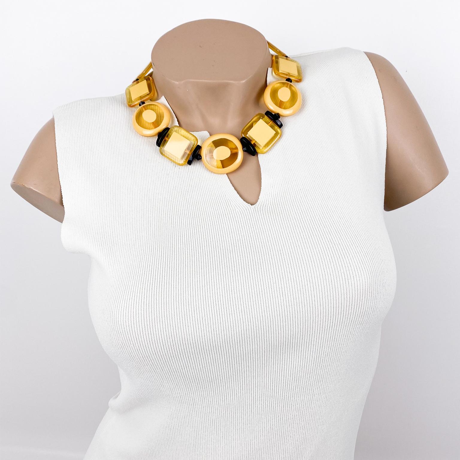 This cute Angela Caputi choker necklace, made in Italy, features a 1970s revival-inspired design with geometric resin pebbles. Each rounded or square pebble bead is carved and slightly domed. The color scheme is playing on a yellow pineapple tone,