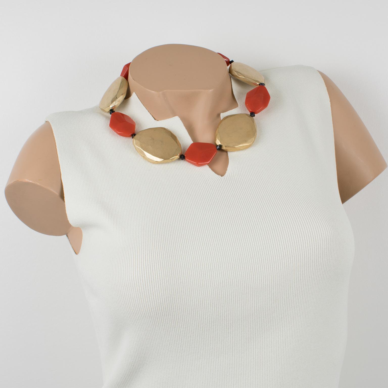 Dieses raffinierte, in Italien gefertigte Halsband von Angela Caputi besteht aus vergoldeten, metallisch beschichteten Harzelementen, die mit flachen, orangefarbenen Perlen kontrastiert werden. Jede organische Kieselsteinperle ist geschnitzt,