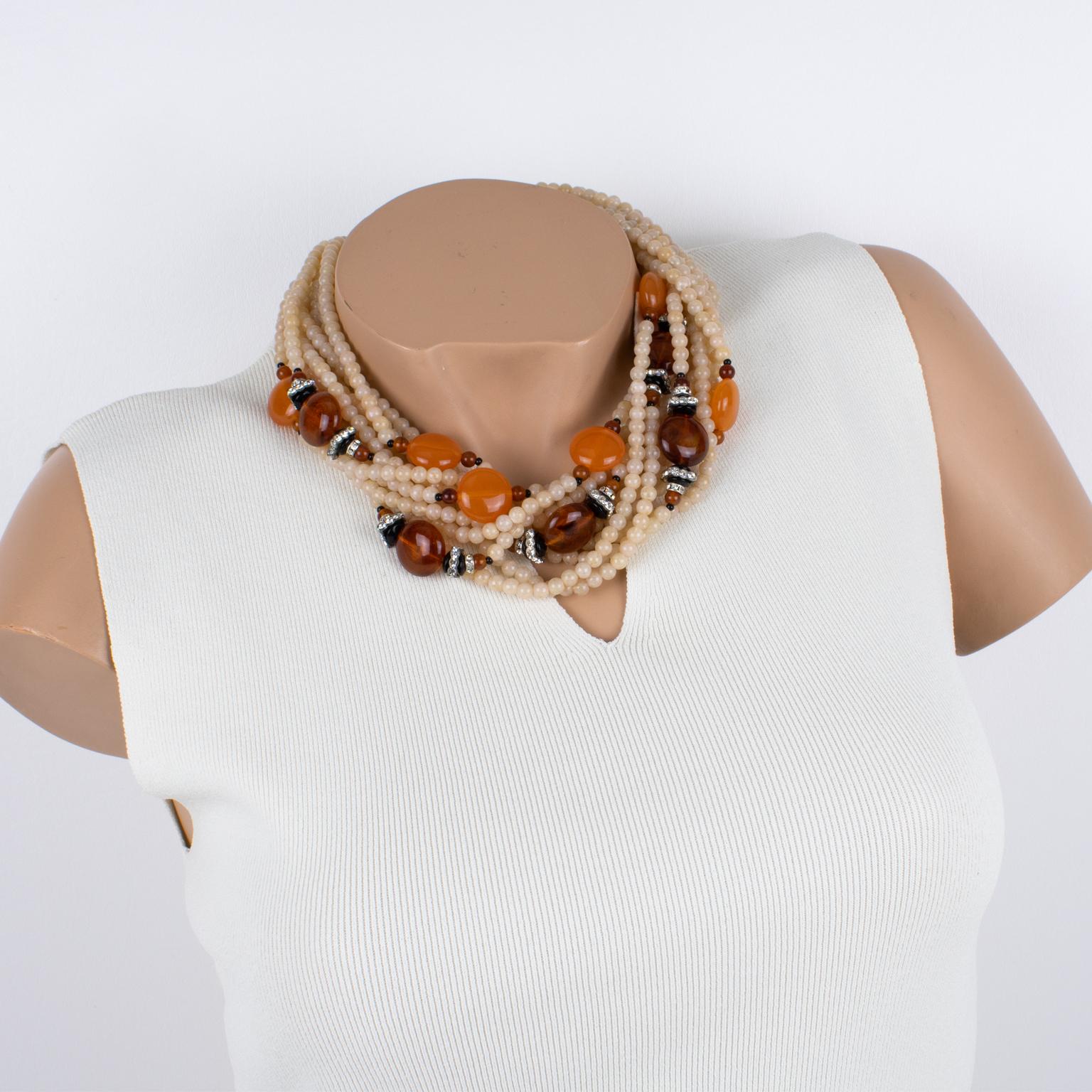 Angela Caputi created this elegant resin-beaded choker necklace in Italy. The piece features an oversized multi-strand design with a dominant pink-white latte color contrasted with amber and tangerine-orange round pebbles and tiny crystal rhinestone