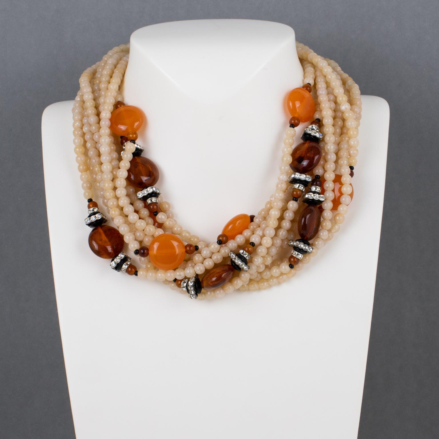 Angela Caputi a cré�é en Italie ce superbe collier ras de cou en perles de résine. La pièce présente un important design multi-brins avec une couleur dominante rose-blanc-vert contrastée par des galets ronds ambre et orange-tangerine et de minuscules