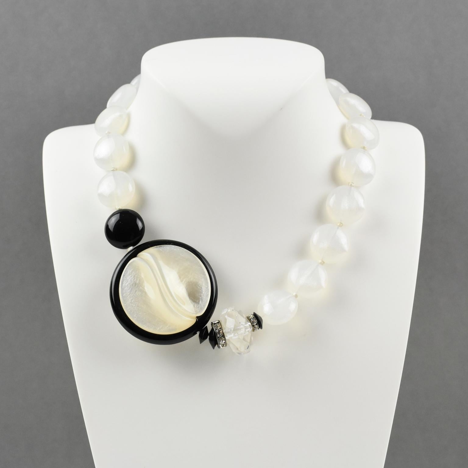 Questa elegante collana di perline a girocollo in resina di Angela Caputi, made in Italy, è caratterizzata da un contrasto bianco e nero. La collana presenta perline assortite e un medaglione laterale. È costruito con perline rotonde bianche