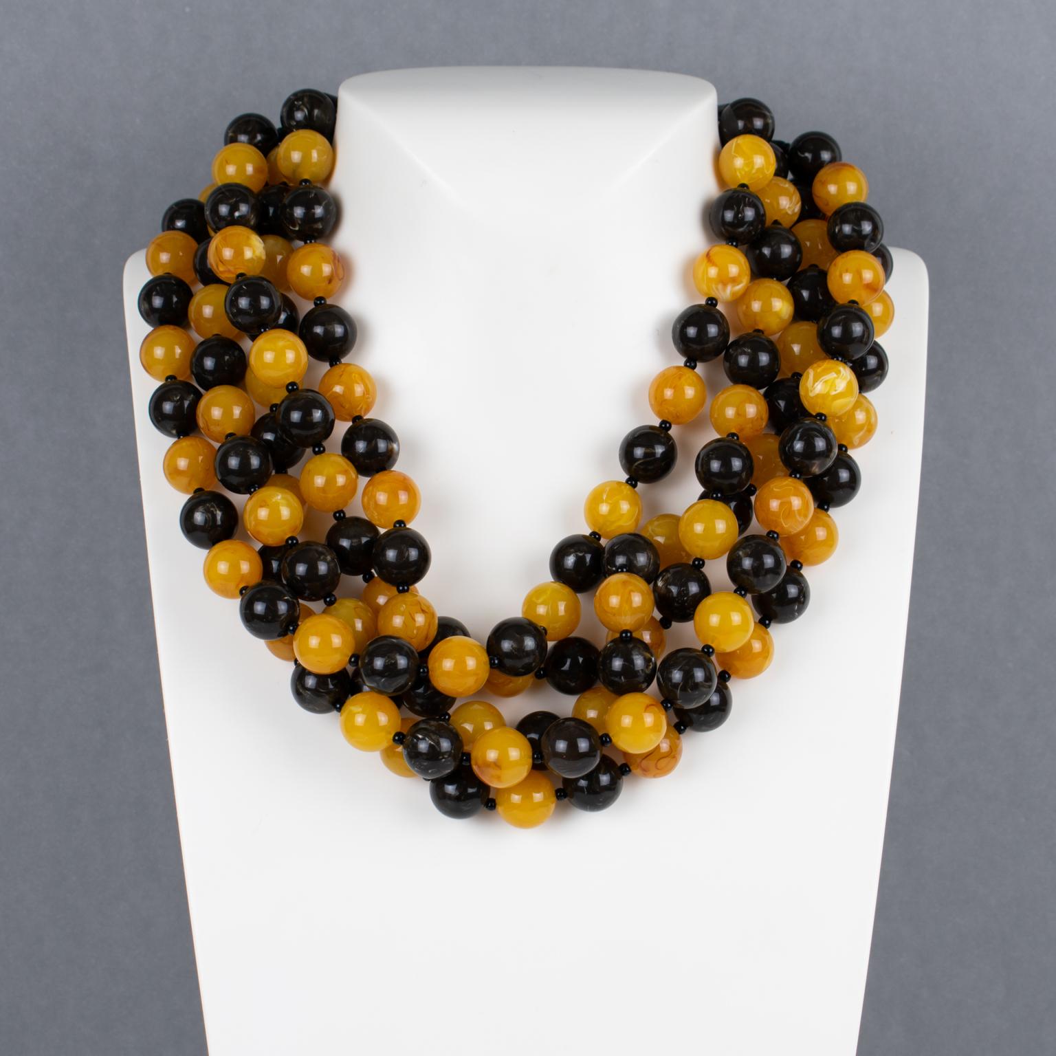 Questa splendida collana di Angela Caputi con perline in resina, realizzata in Italia, presenta un design a più fili di macedonia con perline di semi d'uva nei colori nero e arancione mandarino. I suoi abbinamenti di colore sono sempre di gran