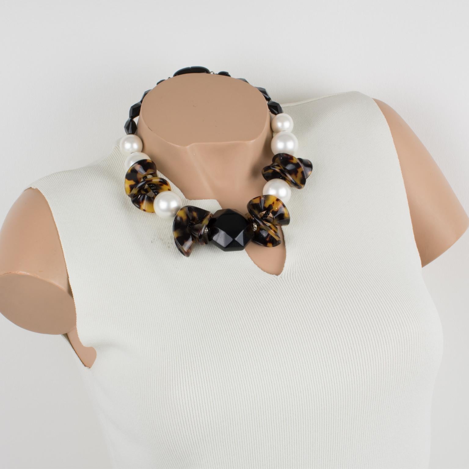 Pretty Angela Caputi, made in Italy Lucite choker beaded necklace. Working in contrast, this necklace features assorted geometric elements. Pearlized white Lucite round beads with jet black Lucite faceted tiny beads and central larger medallion, all