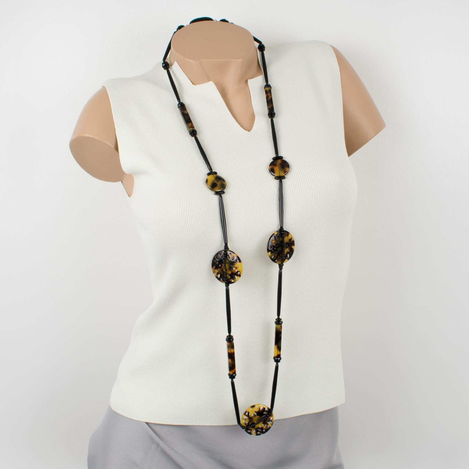 This sophisticated Angela Caputi, made in Italy, beaded necklace features an ethnic-inspired design for that extra-long length built with assorted shaped resin beads imitating tortoiseshell and black jet. Three large medallions are carved and