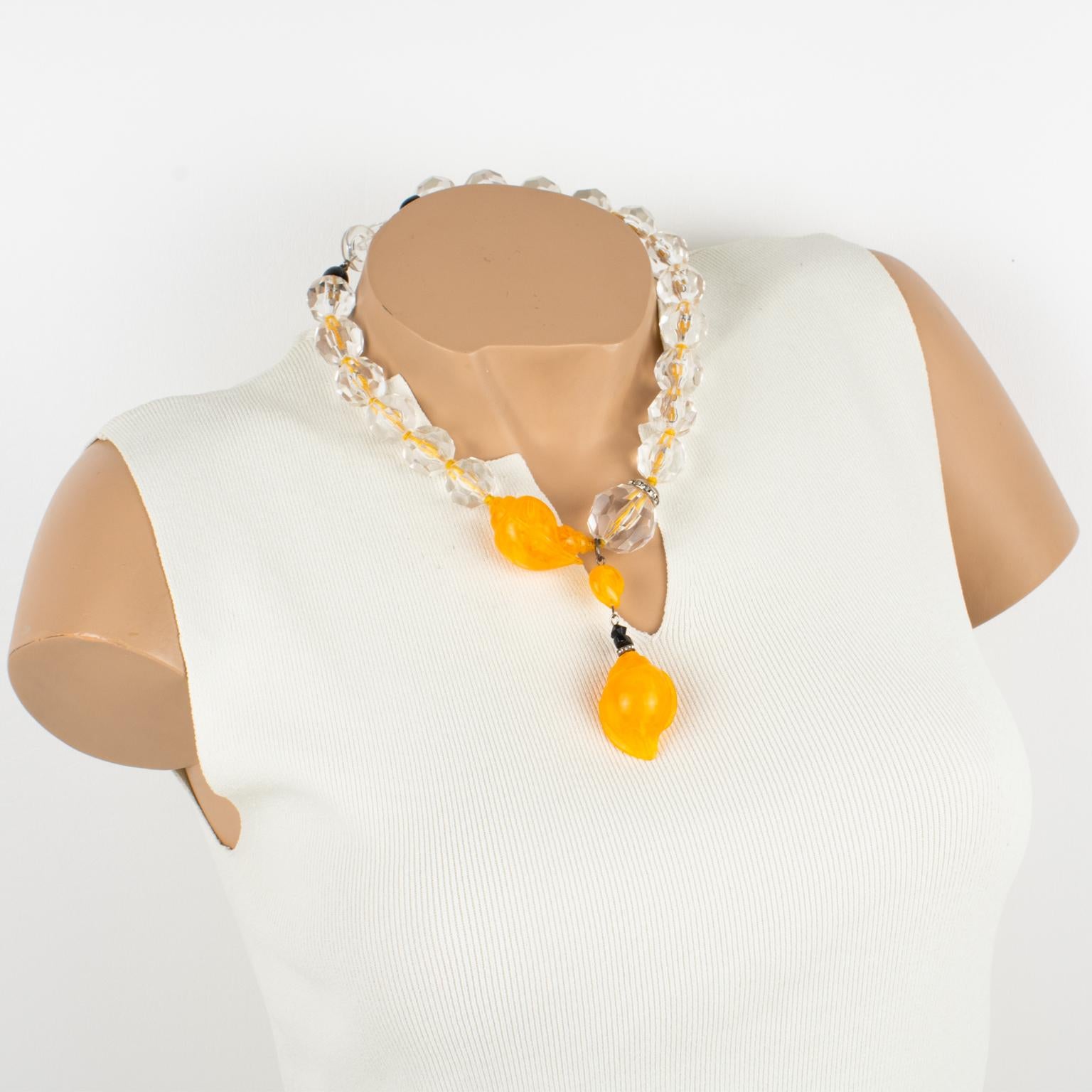 Angela Caputi designed this superb resin choker necklace. This necklace features a set of faceted beads in crystal clear color contrasted with an asymmetric pendant built with orange marble seashell elements. The choker boasts a bright orange thread