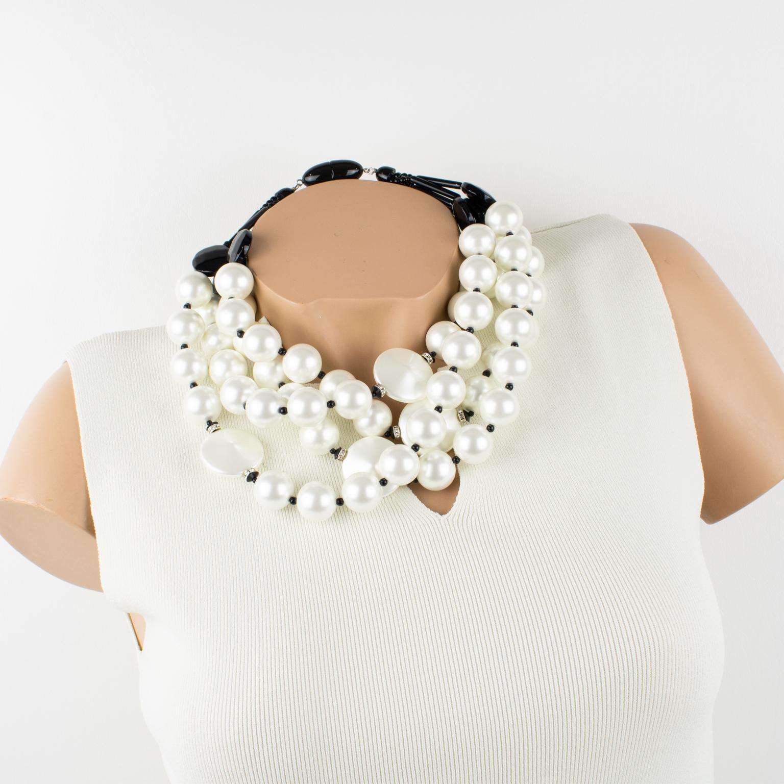 This stunning resin necklace by Angela Caputi contrasts pearlized white with black. The piece was handcrafted in Italy. The choker boasts chunky beads and pebbles in a pearl-imitation textured pattern. The multi-strand shape is contrasted with black