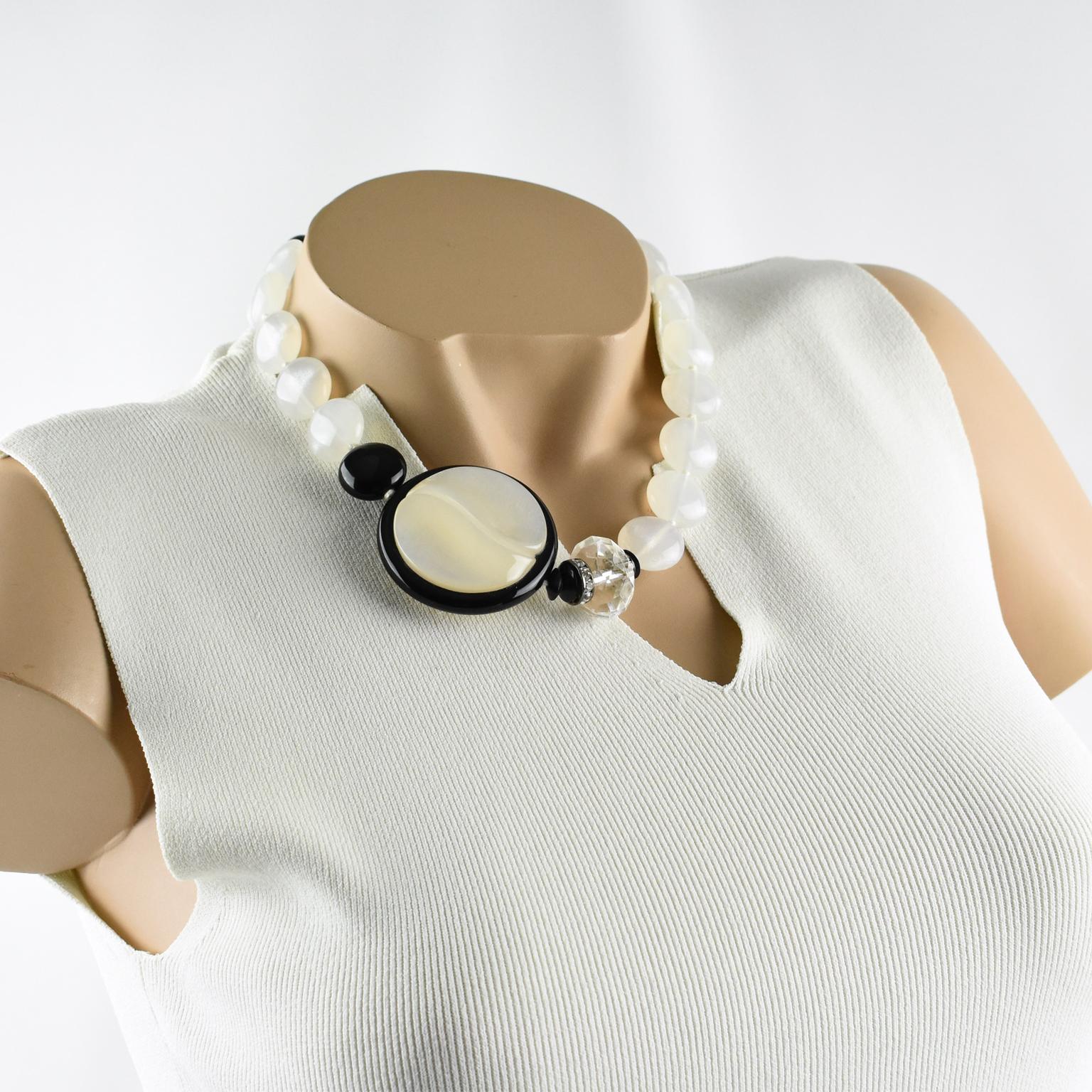 This elegant Angela Caputi, made in Italy resin choker beaded necklace, works with black and white contrast. The necklace features assorted beads and a side medallion. It is built with white opalescent round beads, a single black bead, and a large