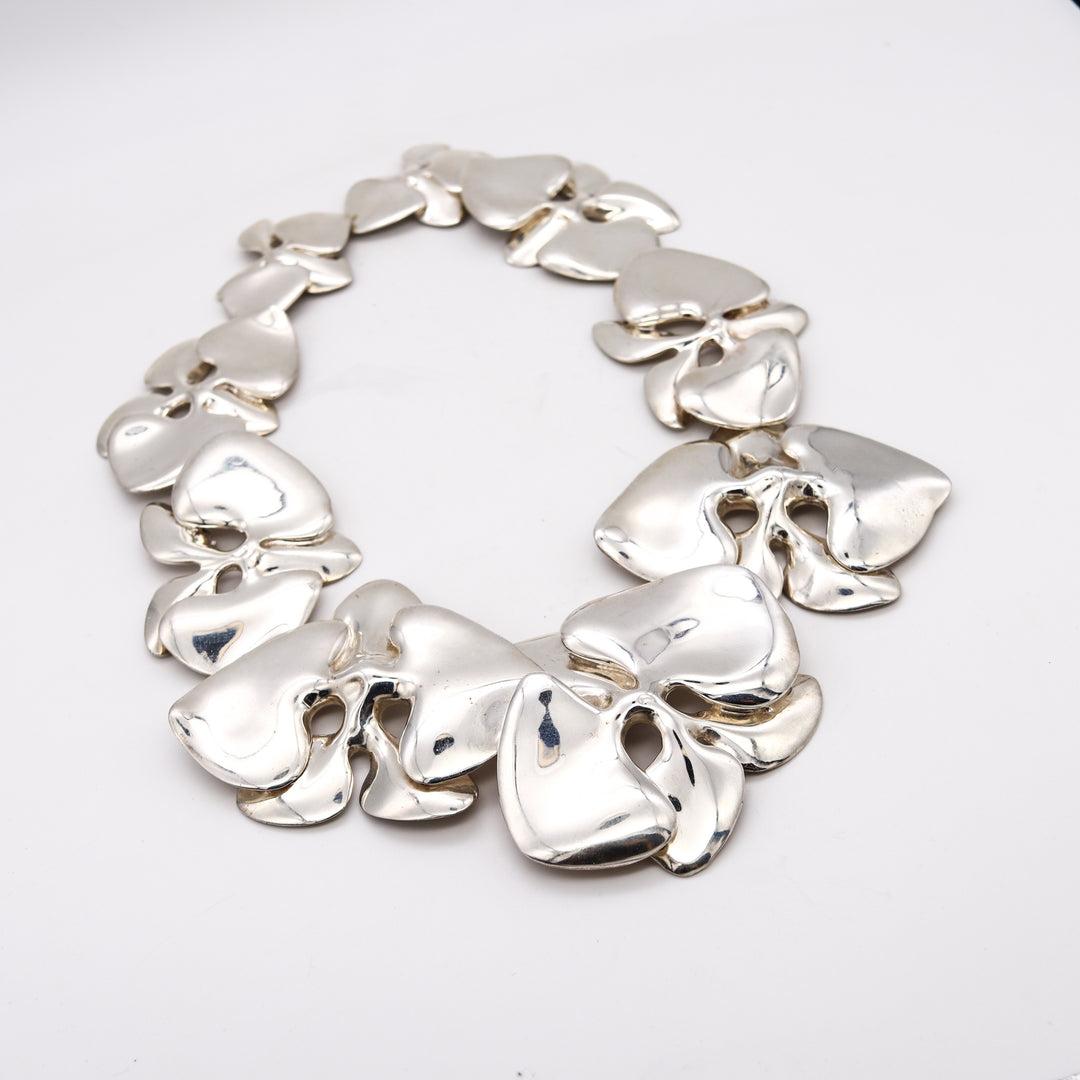 Orchids Necklace designed by Angela Cummings.

An over-sized organic sculptural piece, created in New York city by THE ICONIC Angela Cummings back in the 1984. This necklace was carefully crafted at her own studio in solid .925/.999 sterling silver