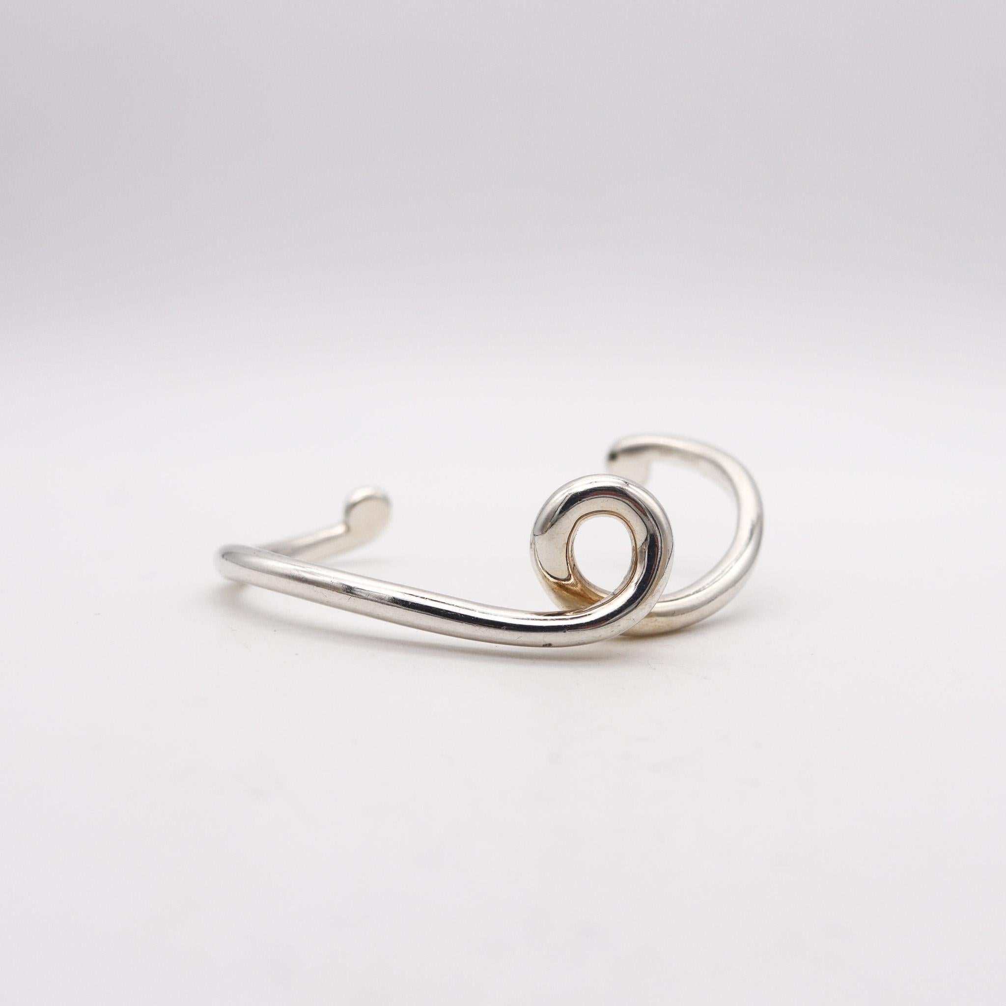 Free form cuff-bracelet designed by Angela Cummings.

Beautiful sculptural cuff bracelet, created by Angela Cummings at her own goldsmith studio in New York city, back in the 1990. This piece has been designed with modernist patterns as a twisted