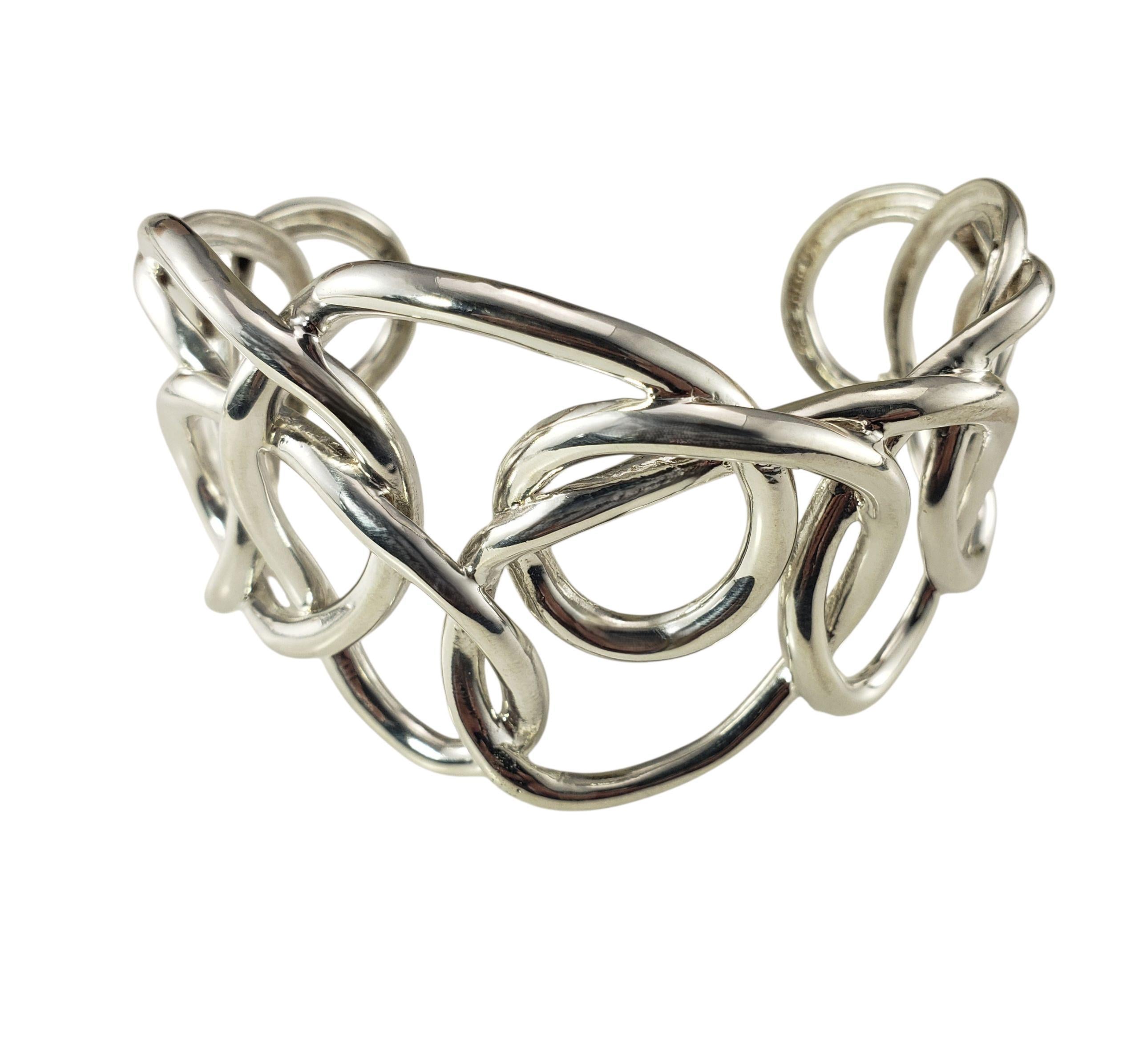 Bracelet manchette en argent sterling d'Angela Cummings AC Studio-

Ce remarquable bracelet manchette présente la signature sculpturale d'Angela Silhouette, avec d'audacieuses boucles imbriquées en argent sterling poli formant une silhouette