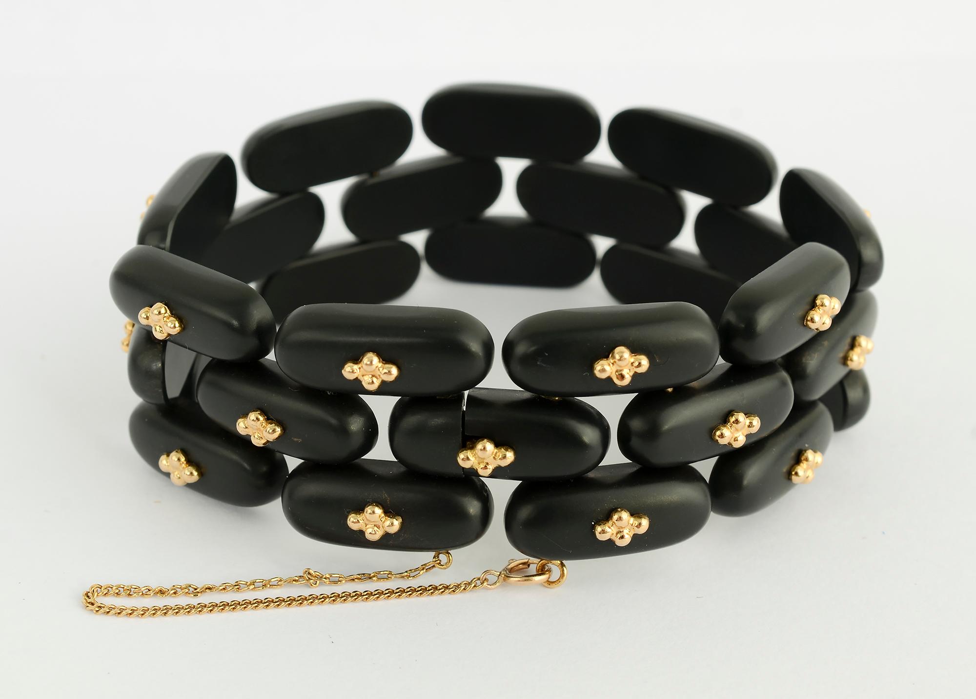 Stunning black jade and gold bracelet and earrings by Angela Cummings. Each link of the bracelet has four gold balls in the center. On each of the earrings, seven groups of the same balls are set on an angle.
The bracelet is 15/16