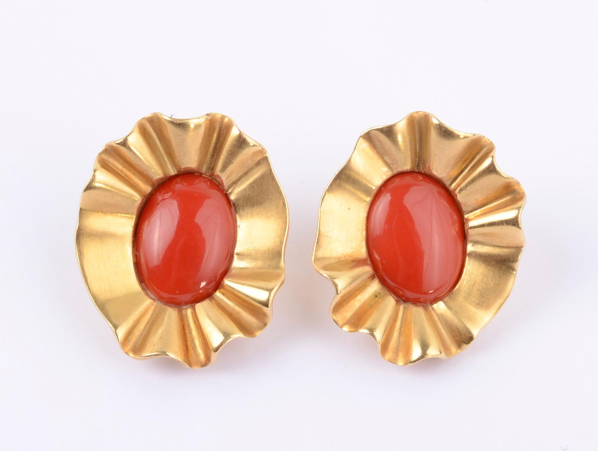 Large, bold ear clips by Angela Cummings. Richly colored coral stones are set in a ruffled 18 karat gold collar. Measurements are 1 inch x 1 1/4 inches. Clips backs can be converted to posts. Signed and dated 1988.
A white spot toward the bottom of