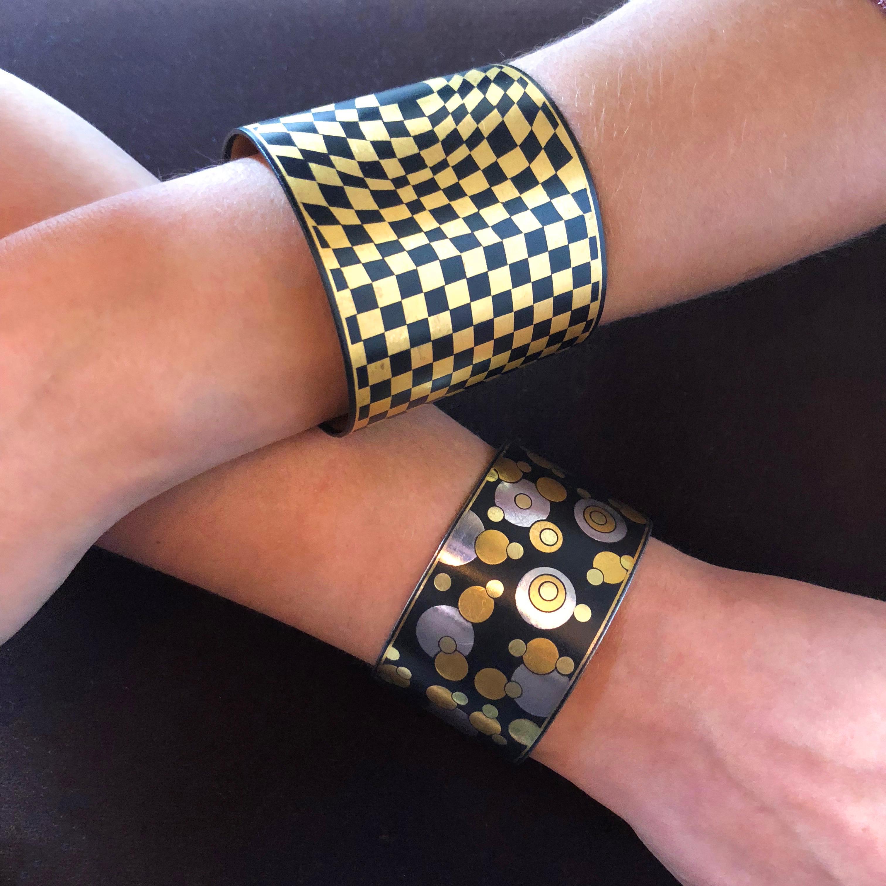 An iconic black iron lacquer cuff inlaid with high karat yellow gold and sterling silver. The  Bubble cuff is by the gifted designer Angela Cummings for Tiffany & Co., c. 1980

The cuff measures 5.5