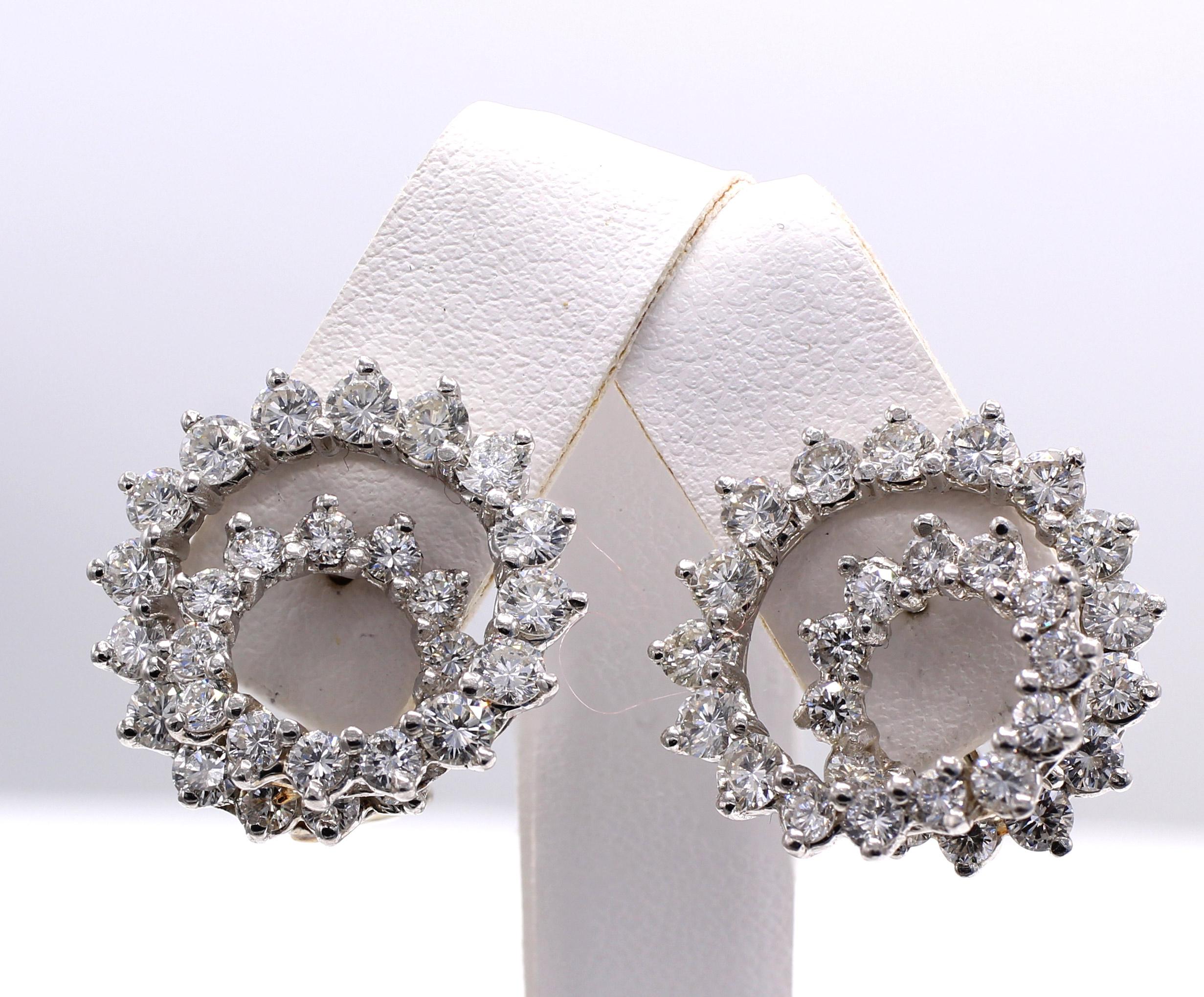 Iconic Swirl or Spiral design ear clips finely handcrafted in platinum. The interesting and three dimensional design spiraling outward from the earlobe gives each of the 56 bright white round brilliant cut diamonds extra sparkle and an amazing