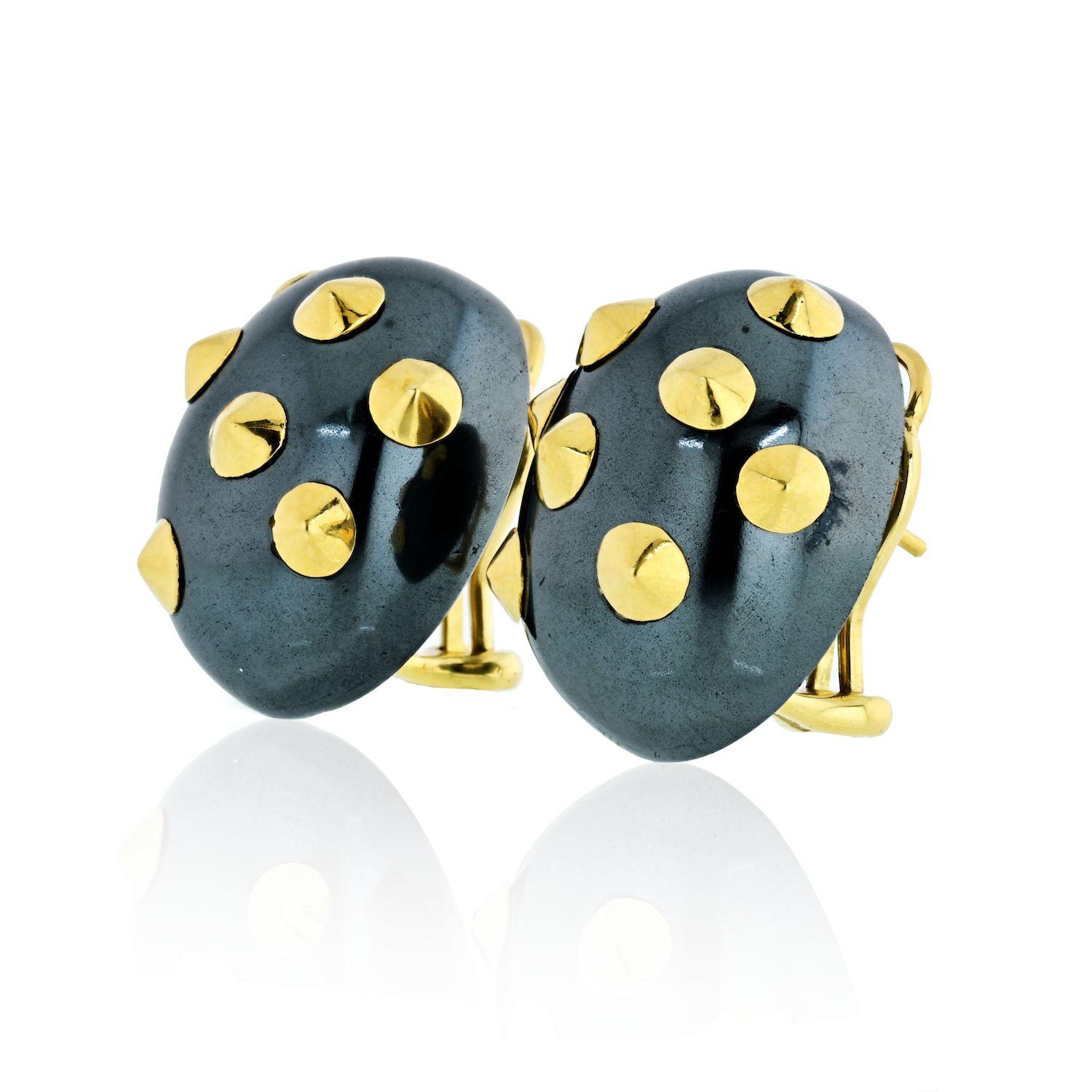 A Pair of Hematite and Gold Earclips. Each designed as a bombé hematite plaque enhanced by polished gold appliqués, mounted in 18K yellow gold, length 1 inch.
Signed 'Cummings'
